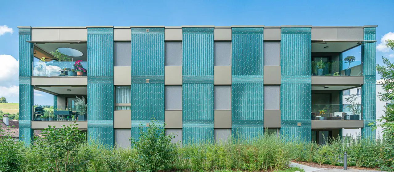 Mehrfamilienhaus mit einer Fassade aus grünen Keramik-Steinen