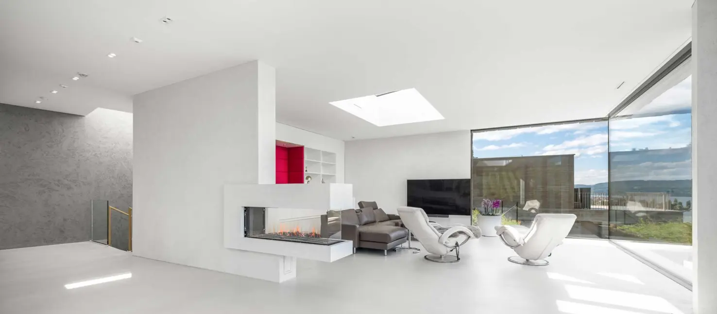 Modernes Wohnzimmer mit viel Weiss und grossen Fenstern mit Akustiksystem von Sto