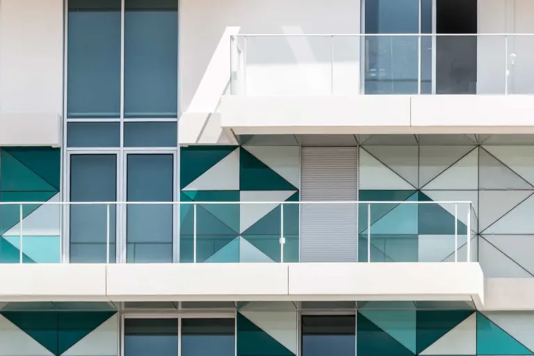 Vorgehängte hinterlüftete Fassaden: Mischfassade aus Putz und Glaspaneelen in Weiß und Blautönen