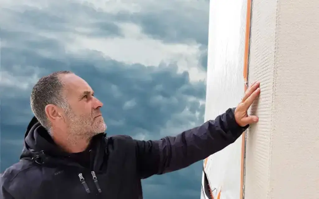 Facharbeiter prüft die Fassade mit der Hand