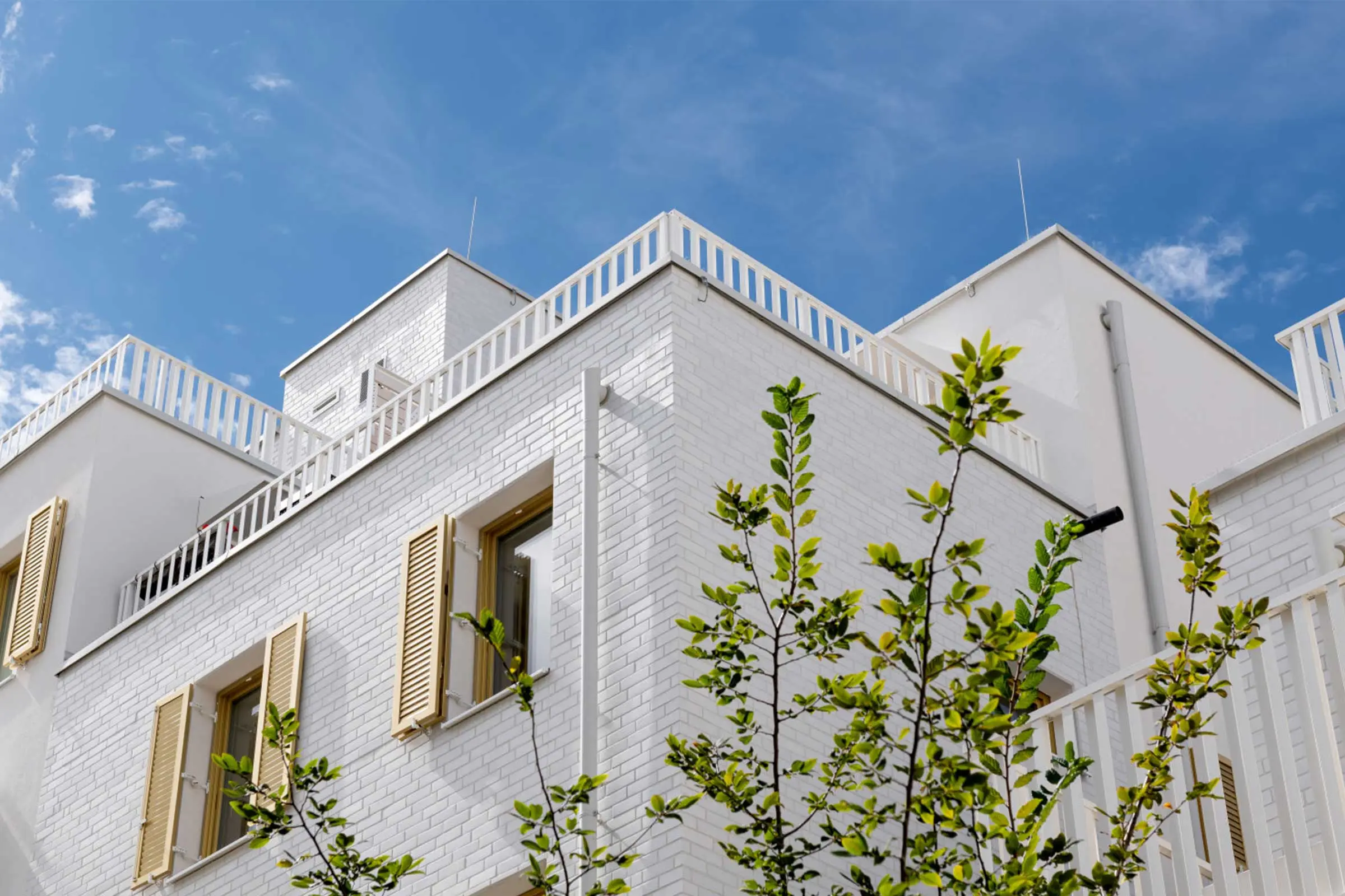 Ausschnitt oberer Teil von Wohnkomplex mit Fassade aus hellem Klinker und Putz