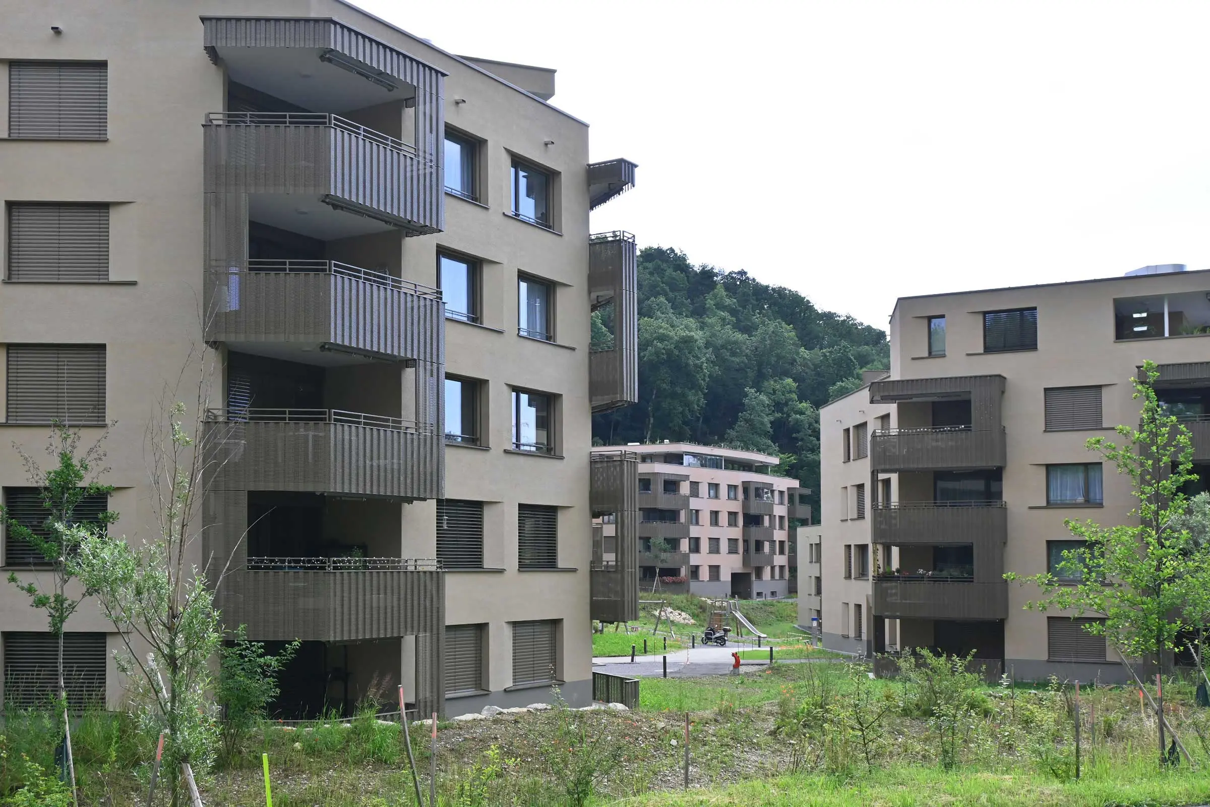 Wohnüberbauung mit mehreren Mehrfamilienhäusern, Fassadenbeschichtung in 2 verschiedenen Brauntönen