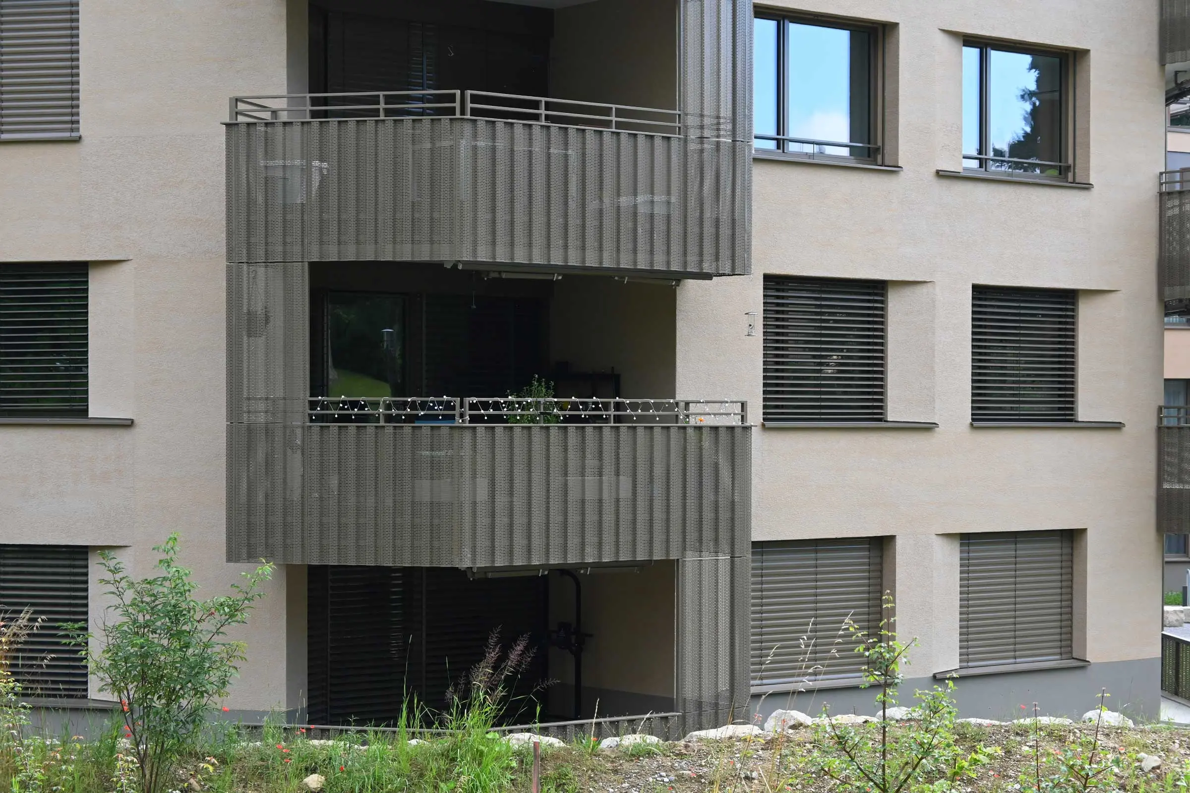 Ansicht einer Fassade in braun mit mehreren Balkonen 