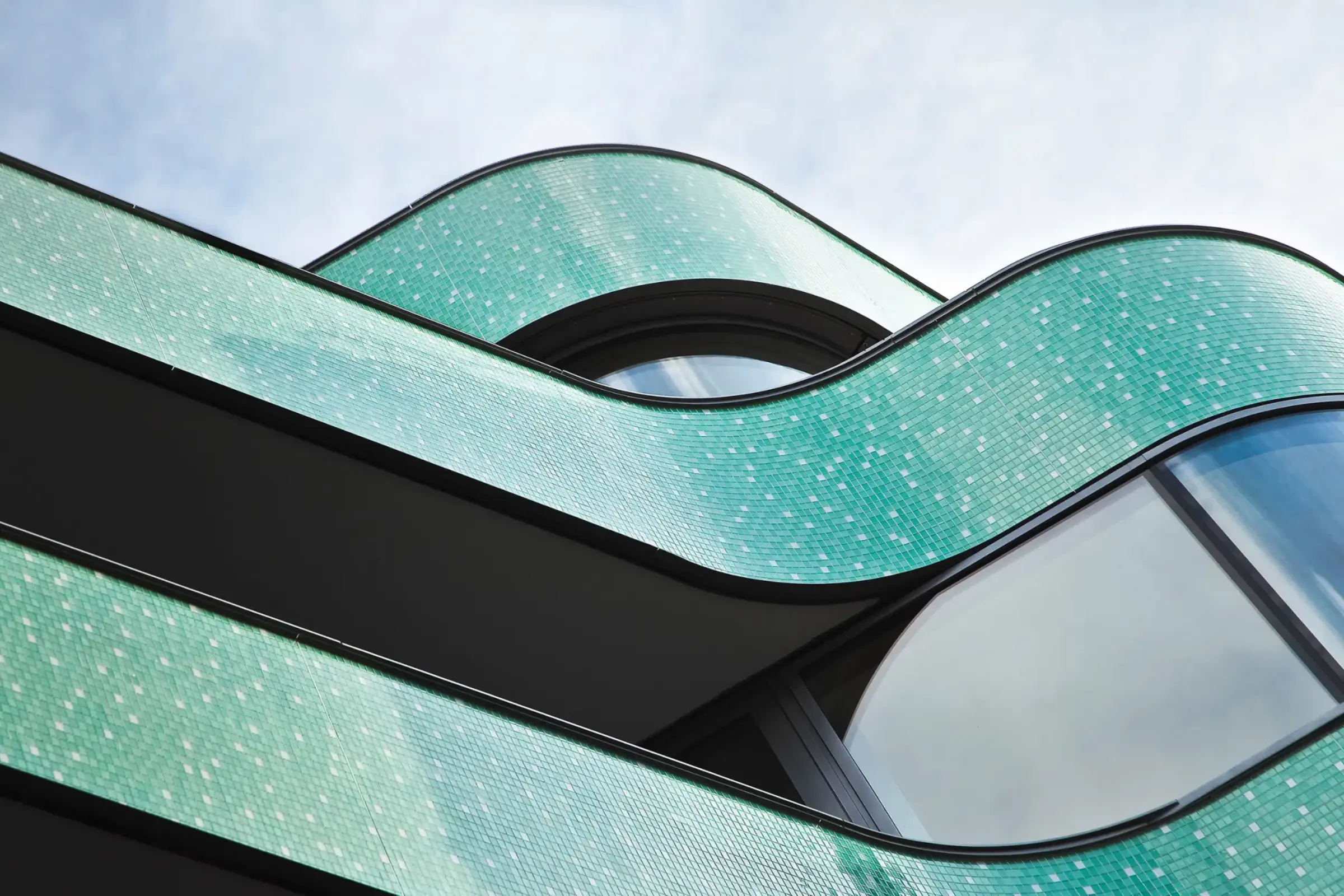 Ansicht von unten von Geschäftsgebäude mit Balkonen mit türkisen Mosaiksteinen