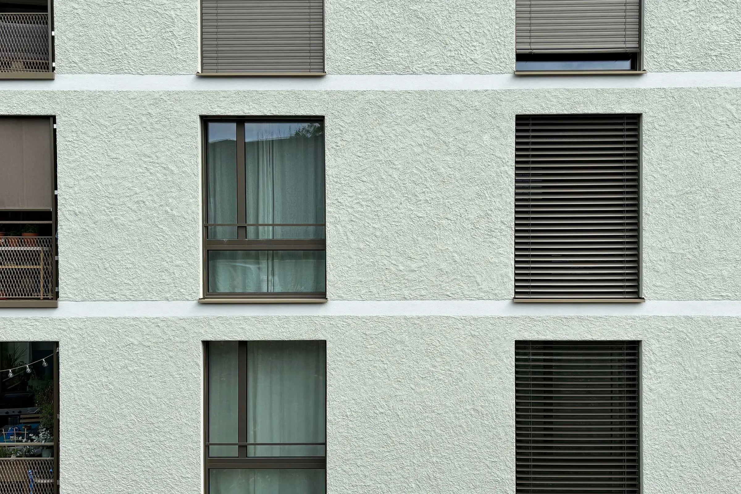 Fassade in hellgrün mit Fensterfront