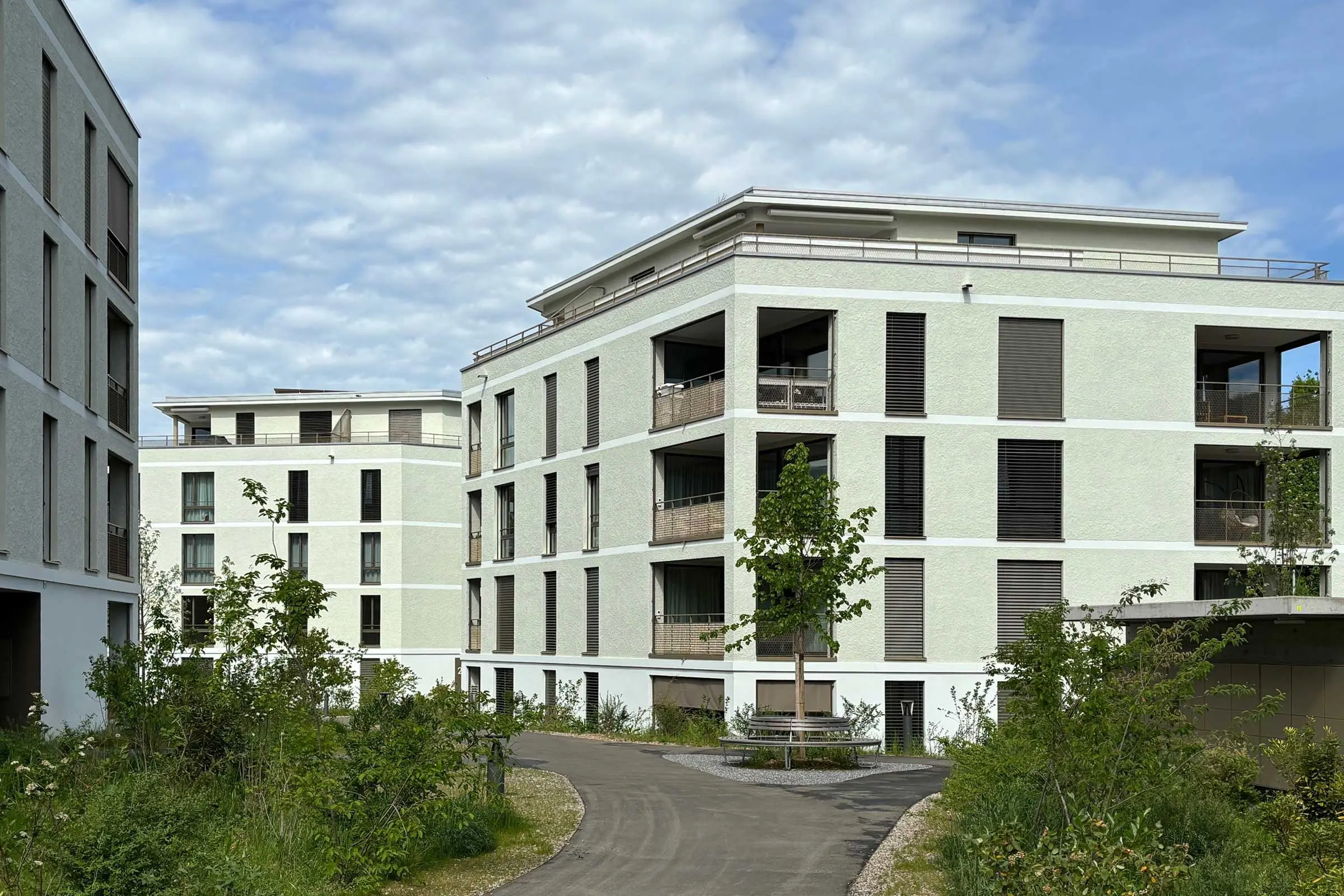 Mehrfamilienhäuser mit hellgrüner Fassade und braunen Fenstern