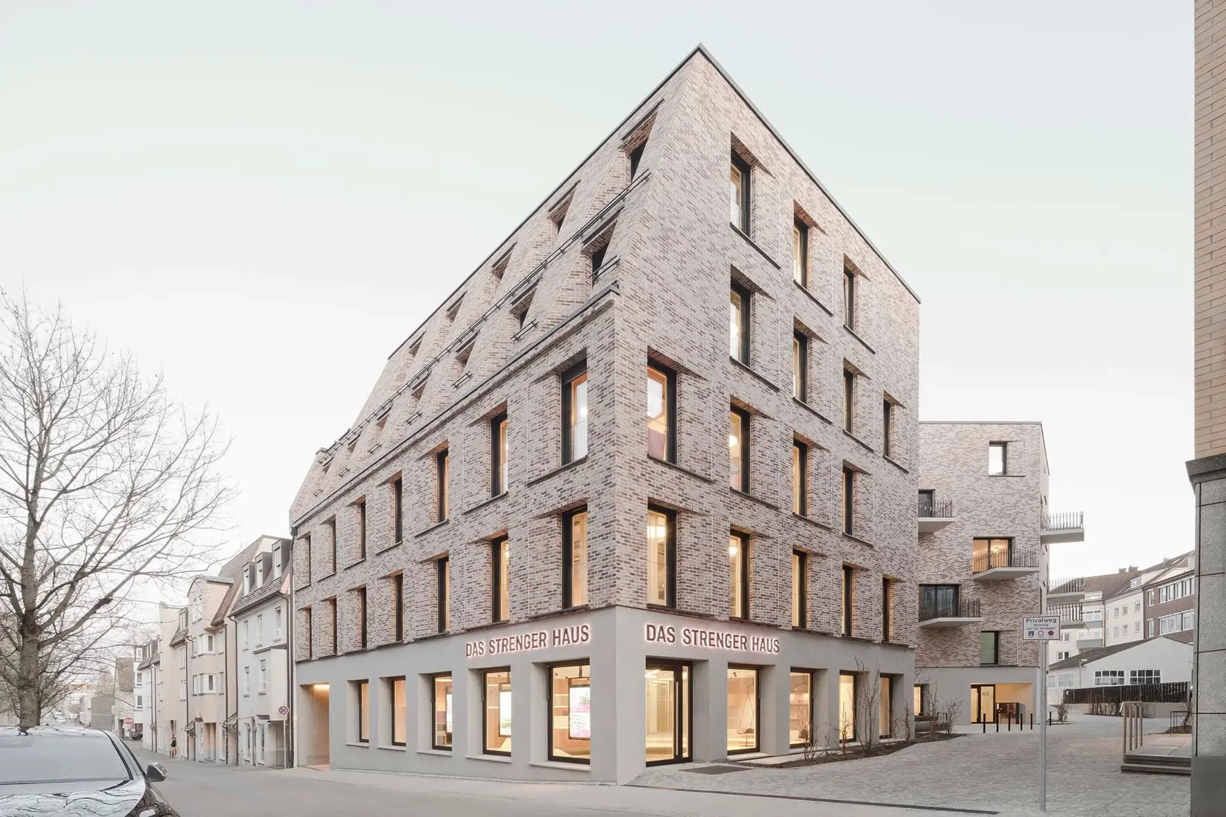 Geschäftshaus mit rötlicher Klinkerfassade und vielen Fenstern 