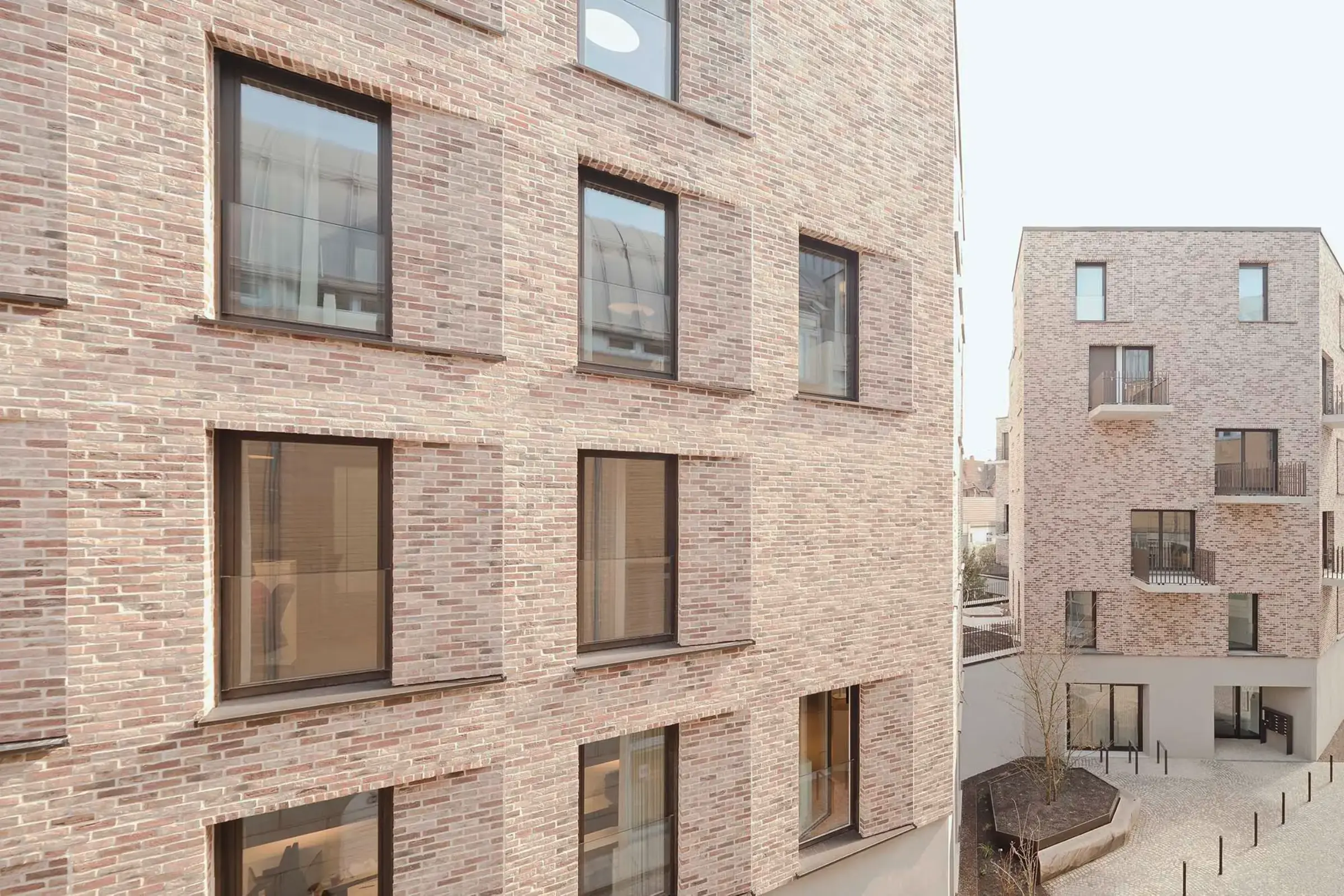 Klinkerfassade mit rötlichem Klinker in HIntergrund ein weiteres Geschäftshaus mit gleichem Klinker