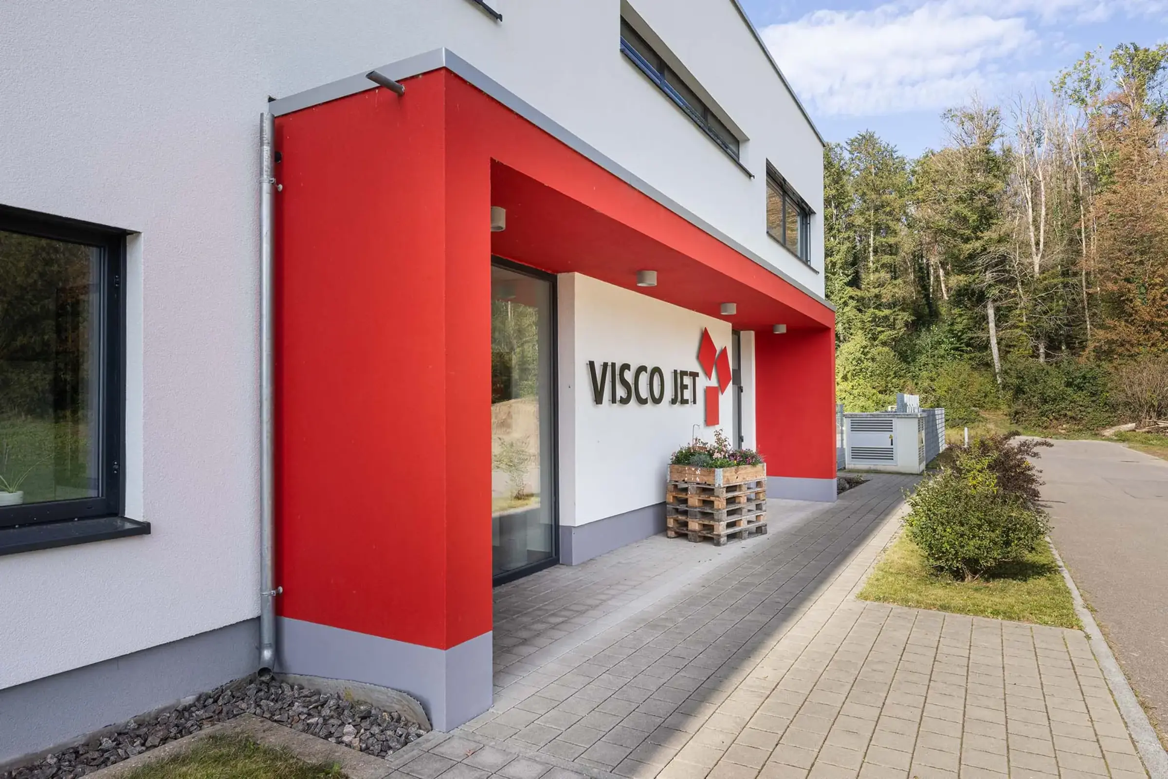 Ansicht Gewerbegebäude Eingangsbereich mit roten Akzenten mit StoColor Dryonic gestrichen