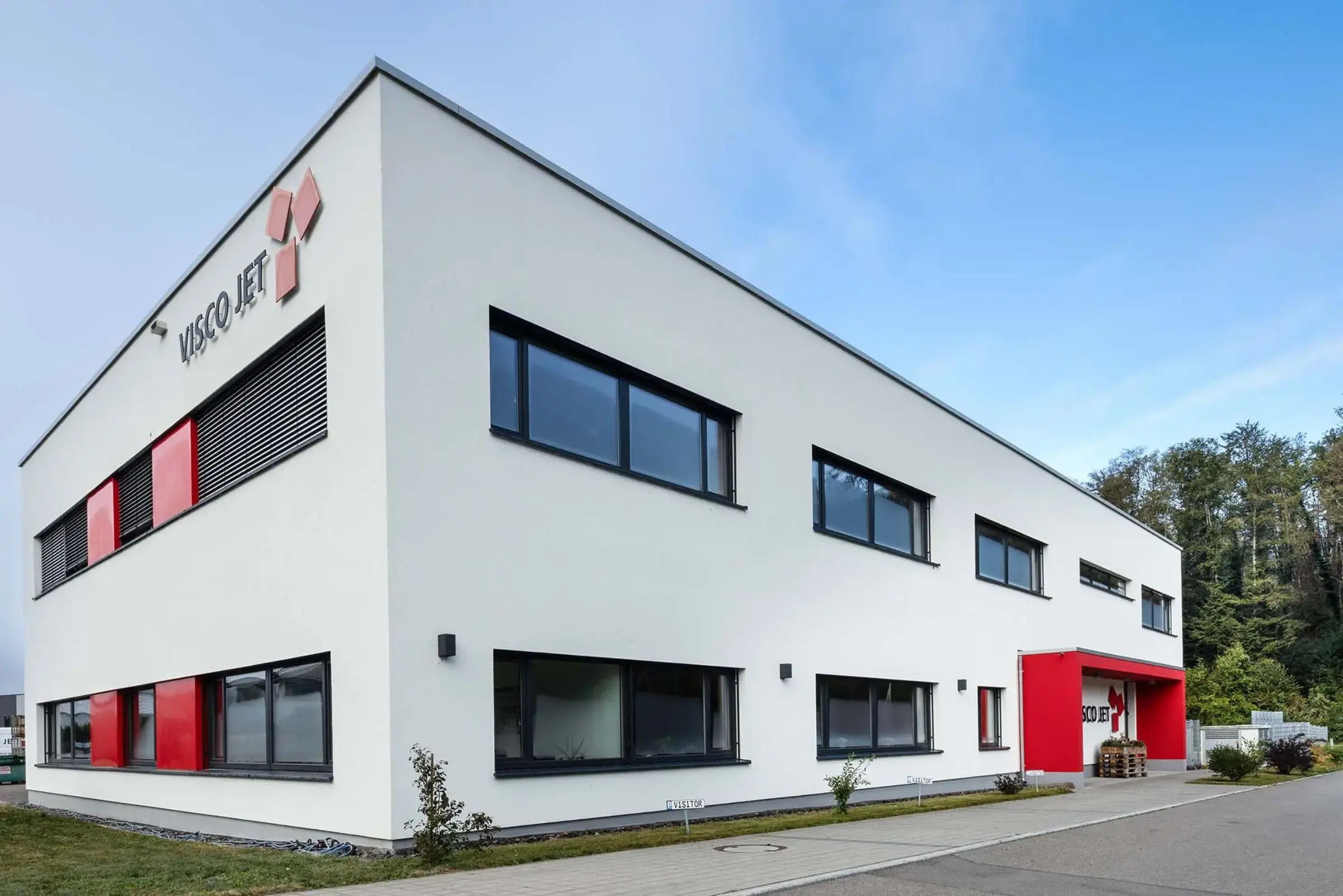 Geschäftsgebäude in Cremeweiss mit roten Akzenten mit der FassadenfarbeStoColor Dryonic S gestrichen