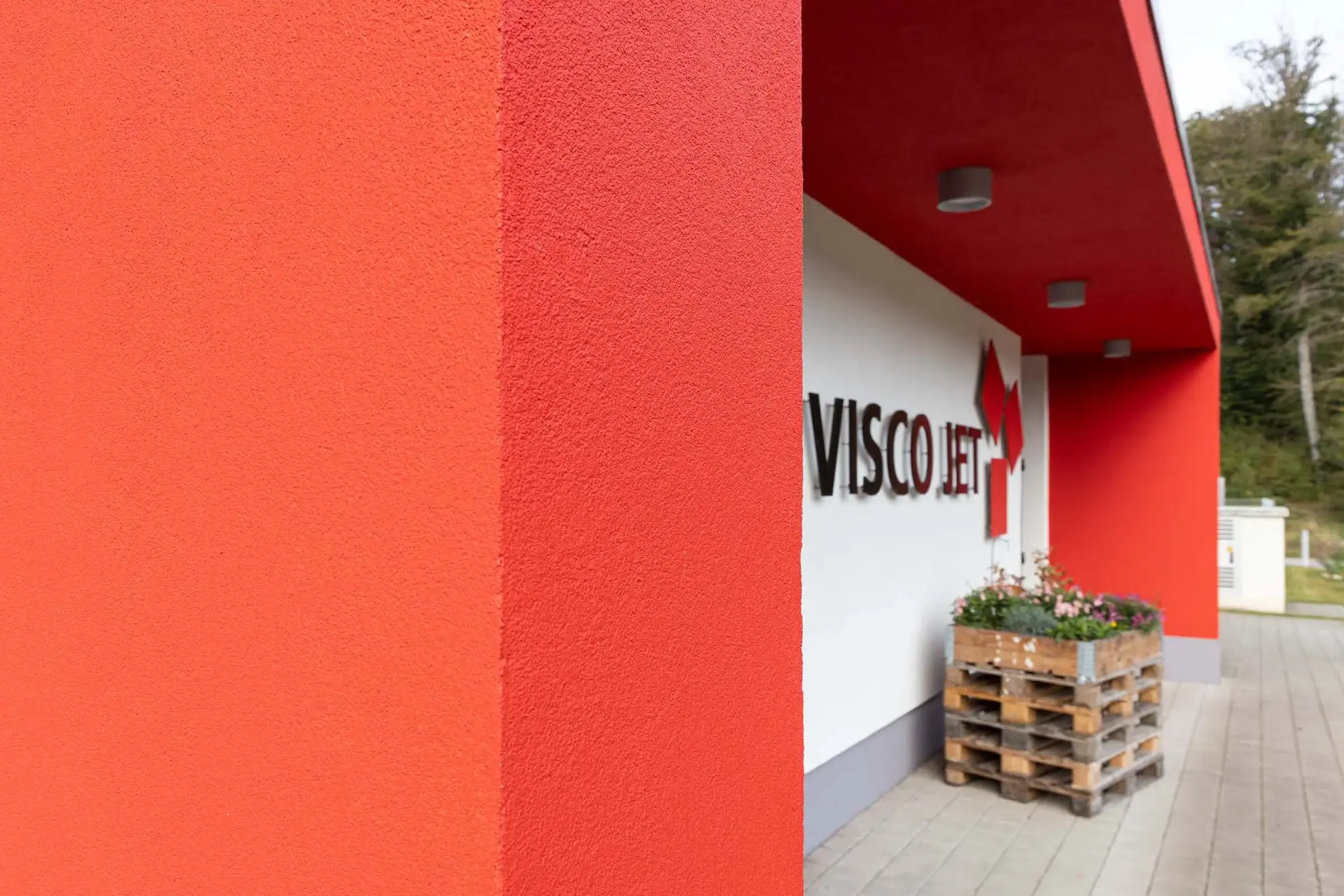 Eingangselement Gewerbegebäude in rot mit StoColor Dryonic S gestrichen.