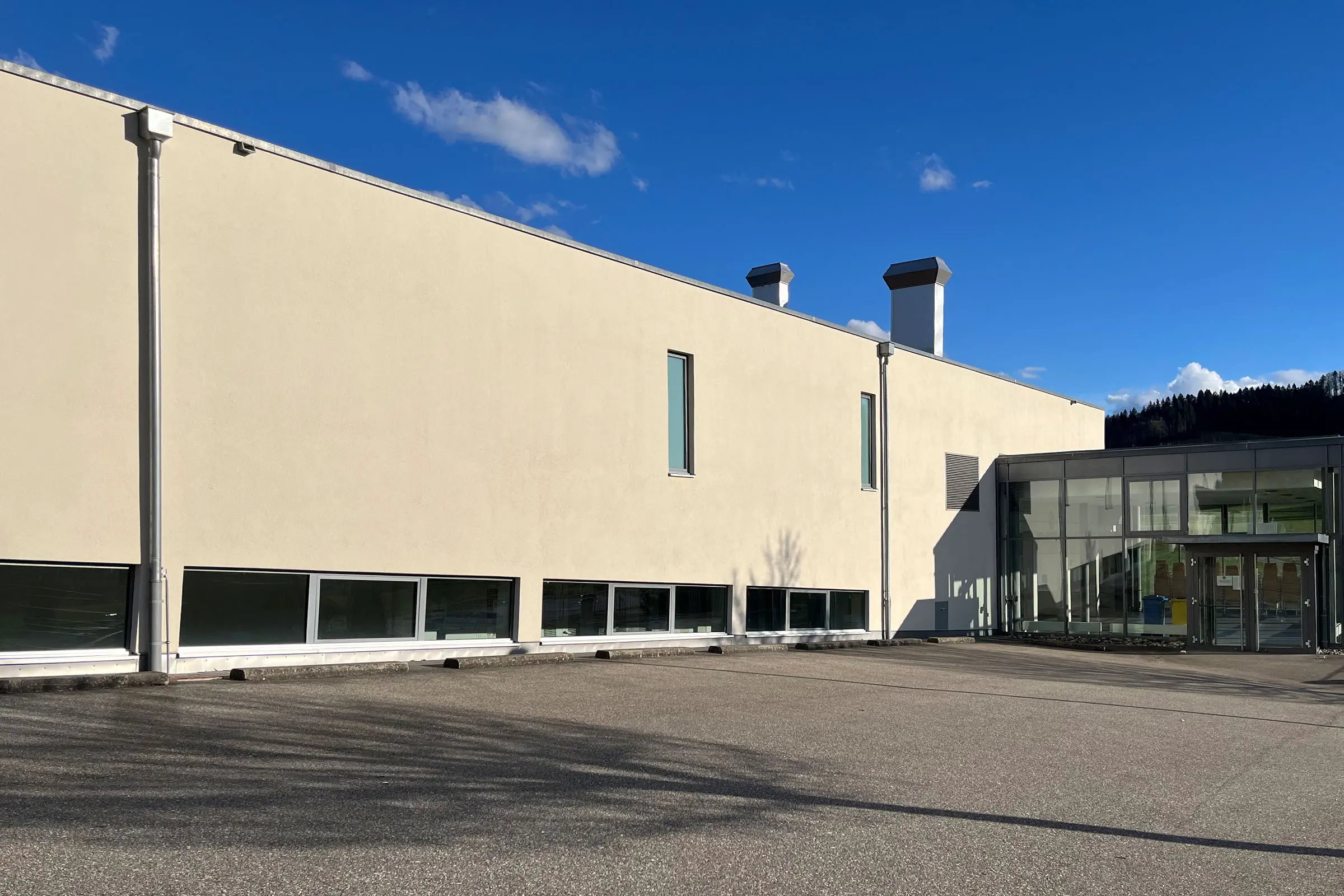 Sanierte Mehrzweckhalle in Hasle mit cremefarbenenm Putz