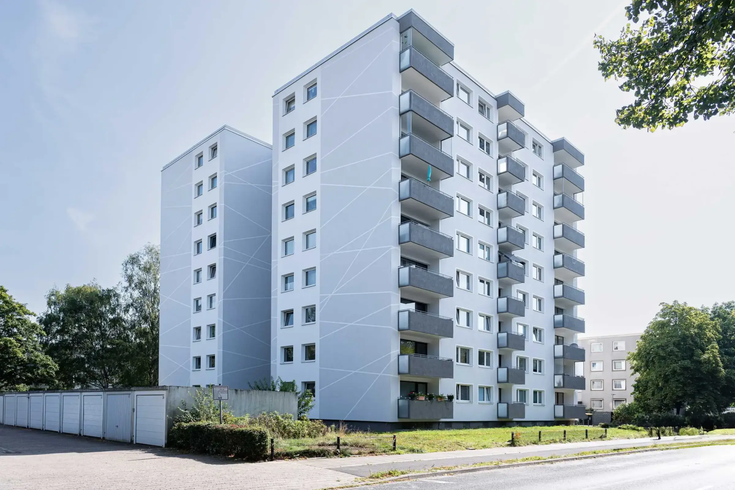 Hochhaus mit weissem Putz und grauen Balkonen