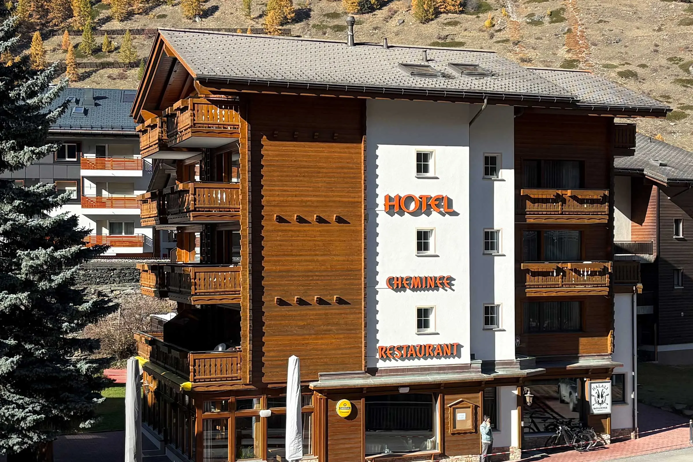 Frontansicht Hotel in Zermatt mit Fassade aus Holzverkleidung und heller Fassadenbeschichtung
