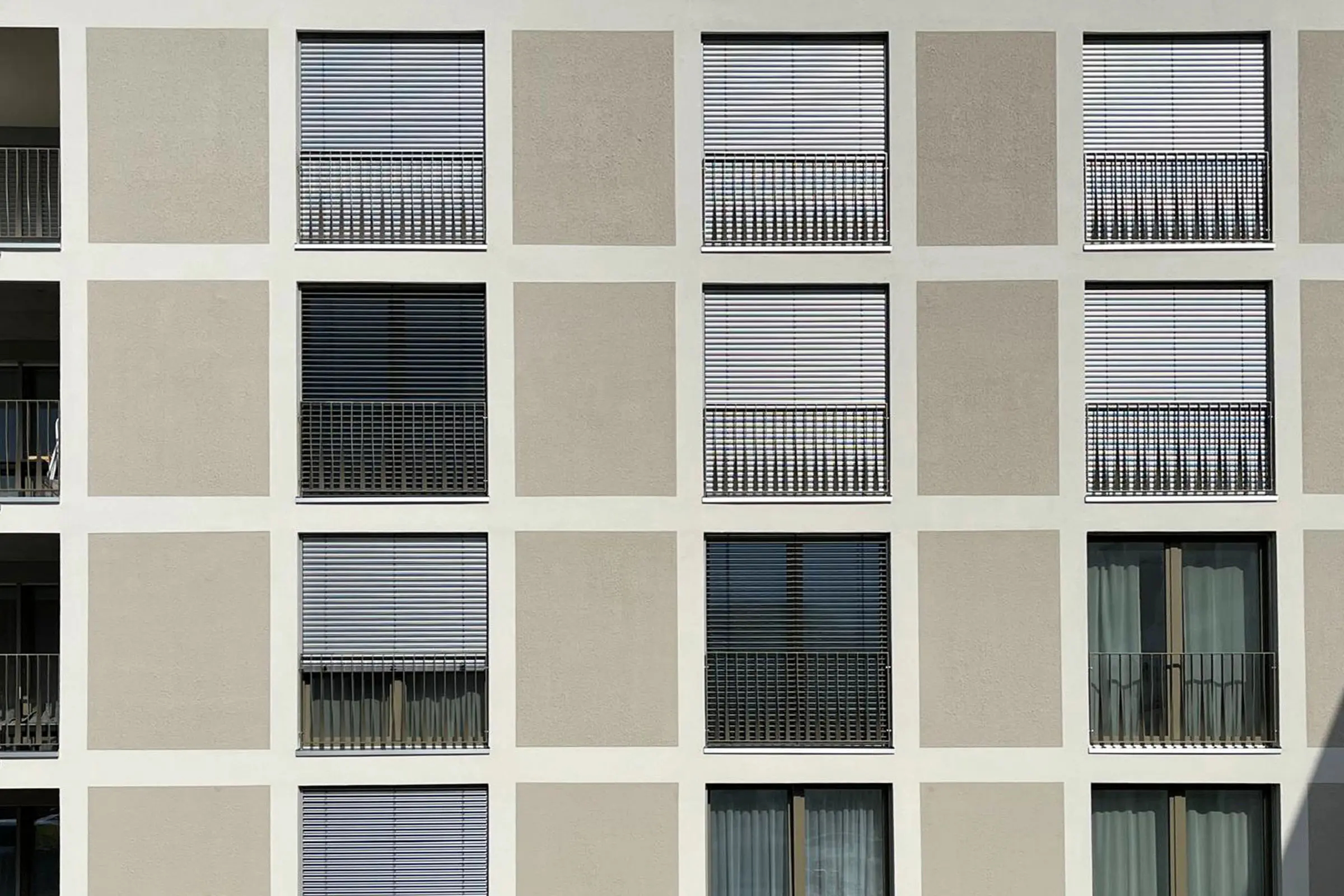 Ansicht Fensterfront mit braunem Putz und beigem Putz um die Fenster