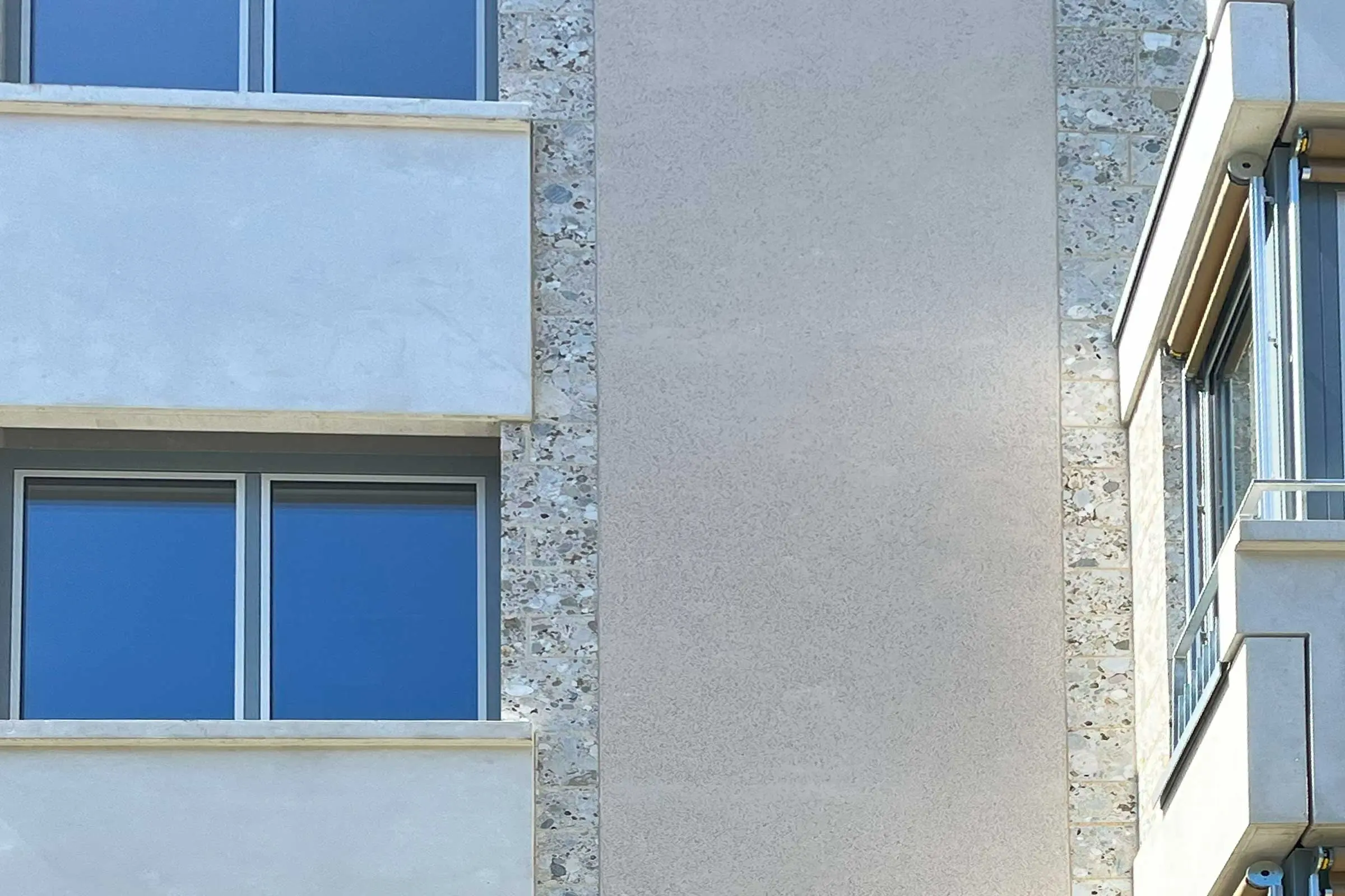 Ansicht Fenster eines MFH mit Steinumfassung der Fenster in Beige