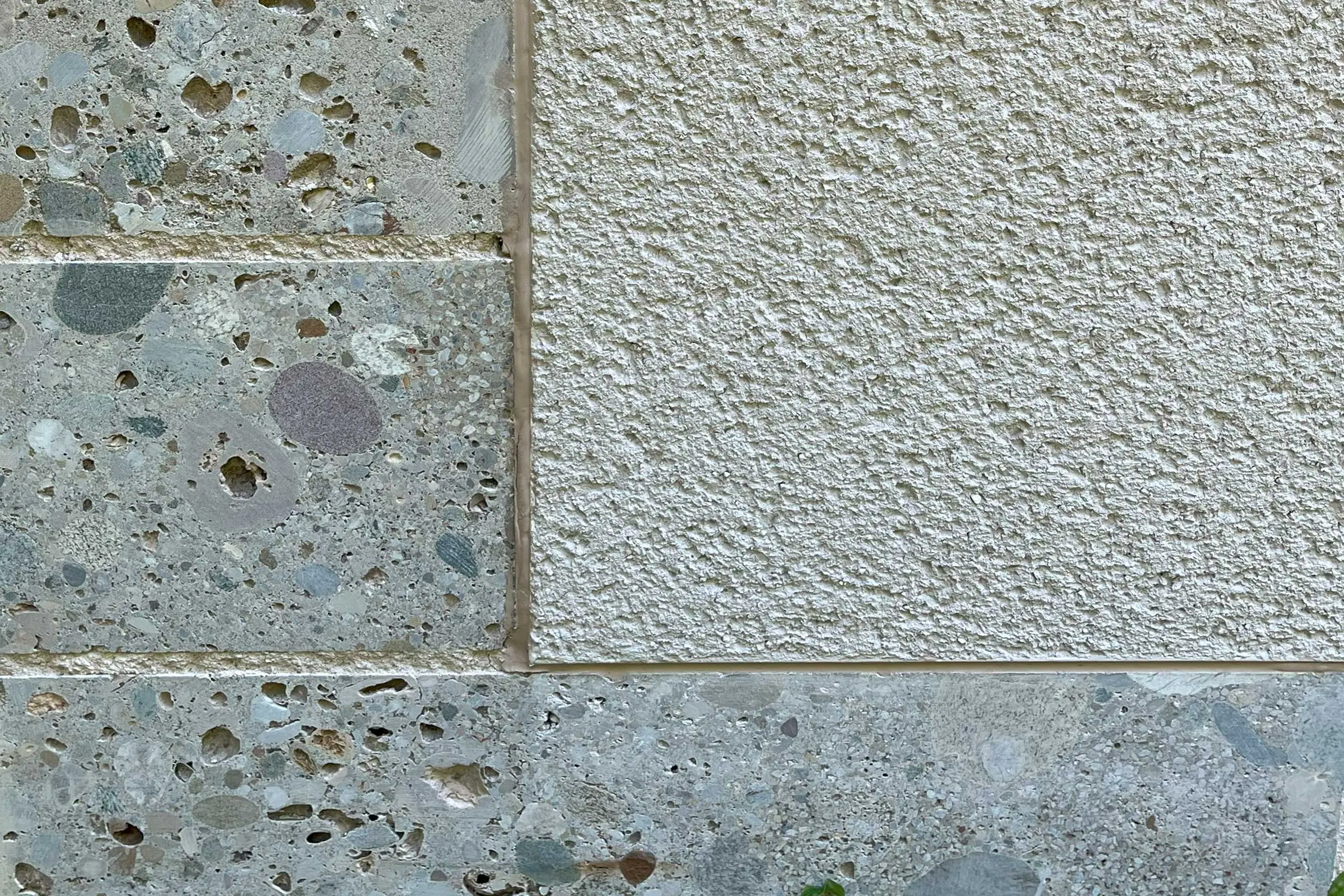 Nahaufnahme der Steinumrandung der Fenster mit angrenzendem Putz in beige