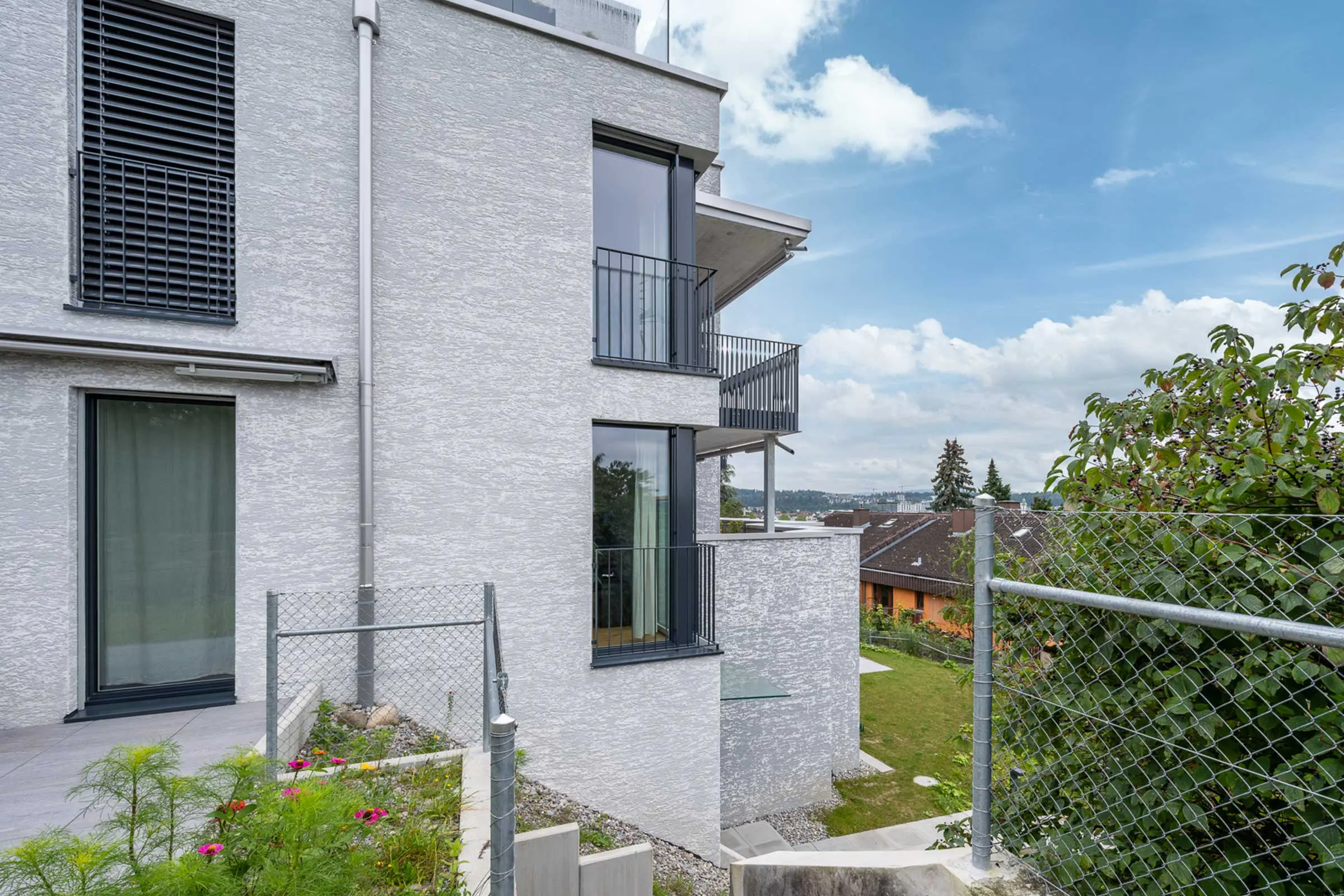 Ansicht MFH mit Fensterfront mit Fassadenbeschichtung StoMiral Edelkratzputz in beige