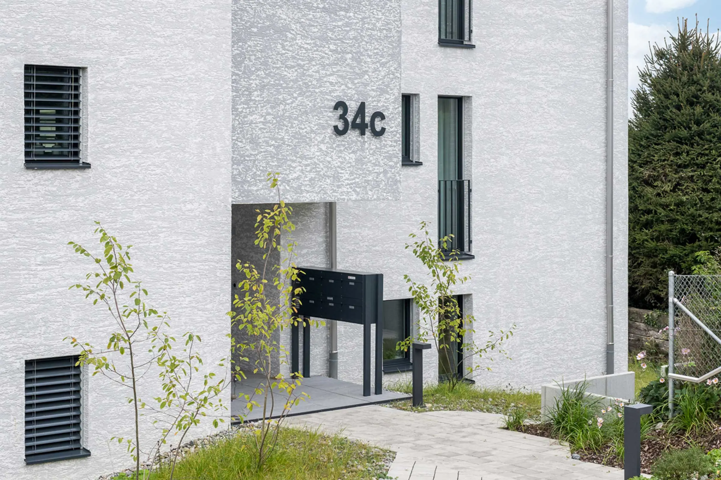 Eingangbereich MFH mit Fassadenbeschichtung StoMiral Edelkratzputz in beige