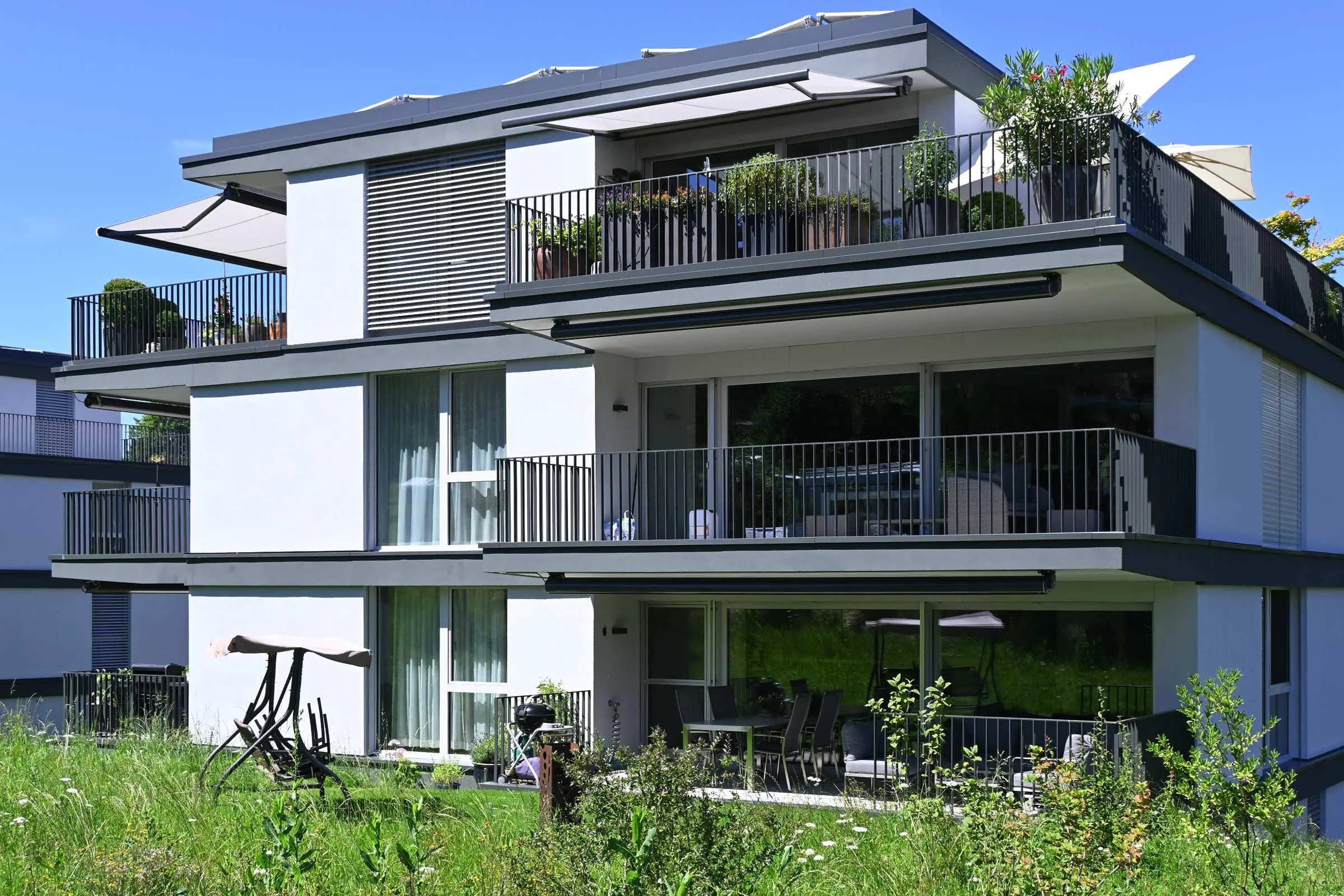 Ansicht Vorderseite eines Mehrfamilienhauses mit heller Fassade und Balkonen