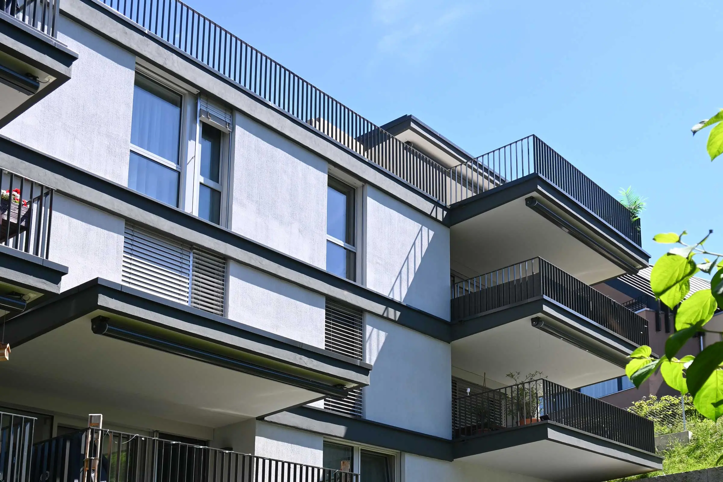 Hintere Hausansicht von Mehrfamilienhaus mit Balkonen und Fenstern