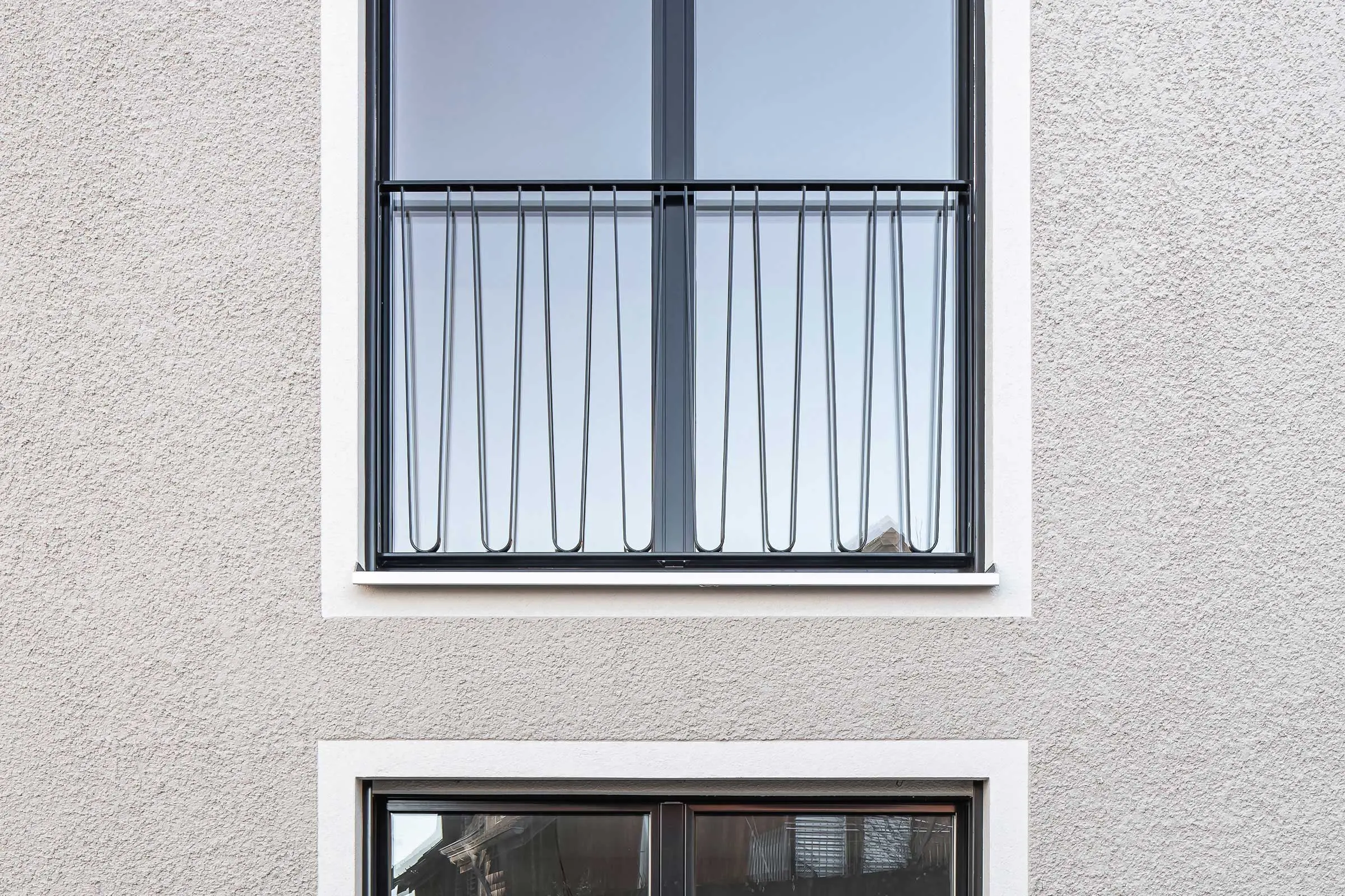 Fensterausschnitt mit kleinem Balkon und heller Fassade