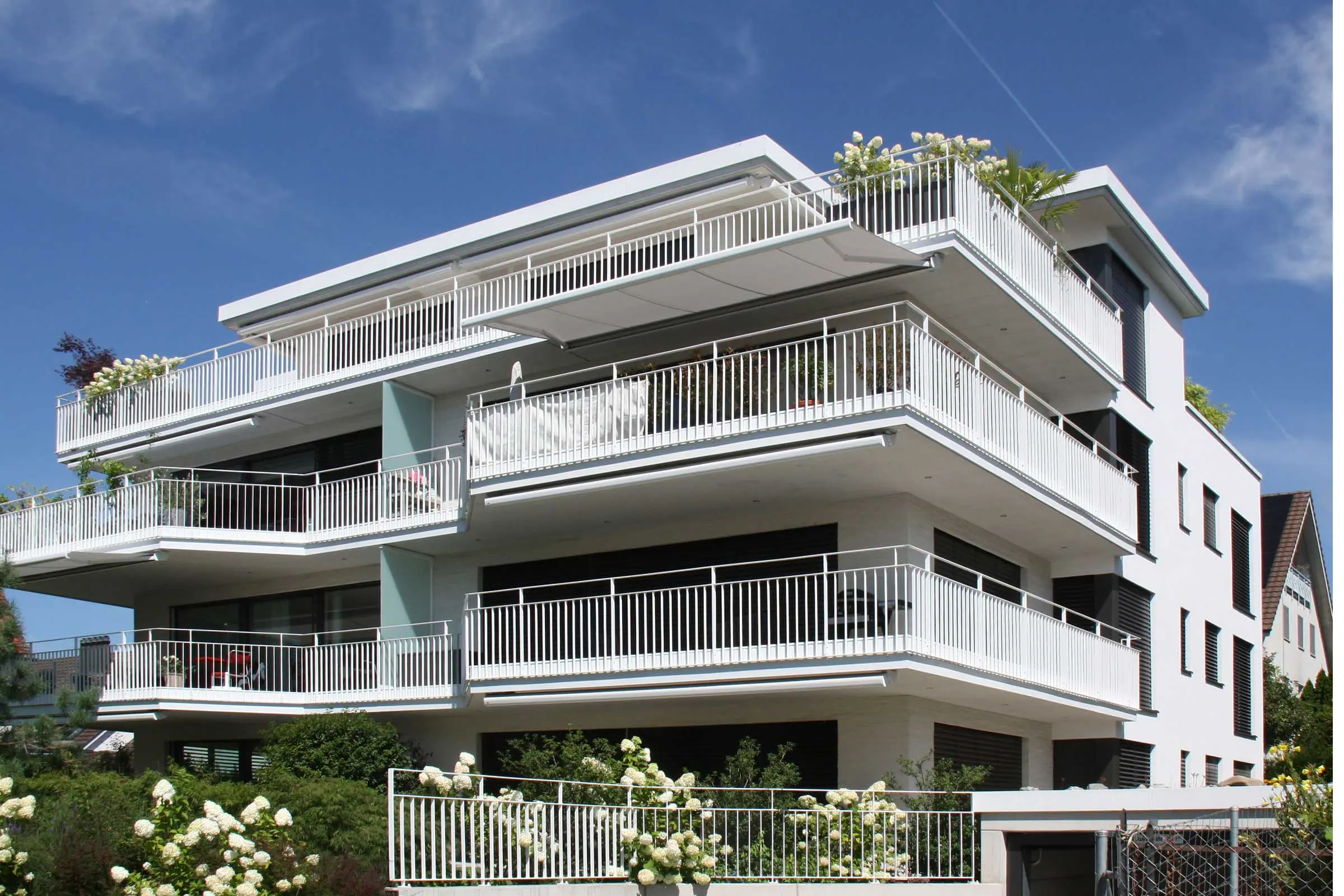 Mehrfamilienhaus mit vielen Balkonen in weiss mit Fassadenfarbe von Sto