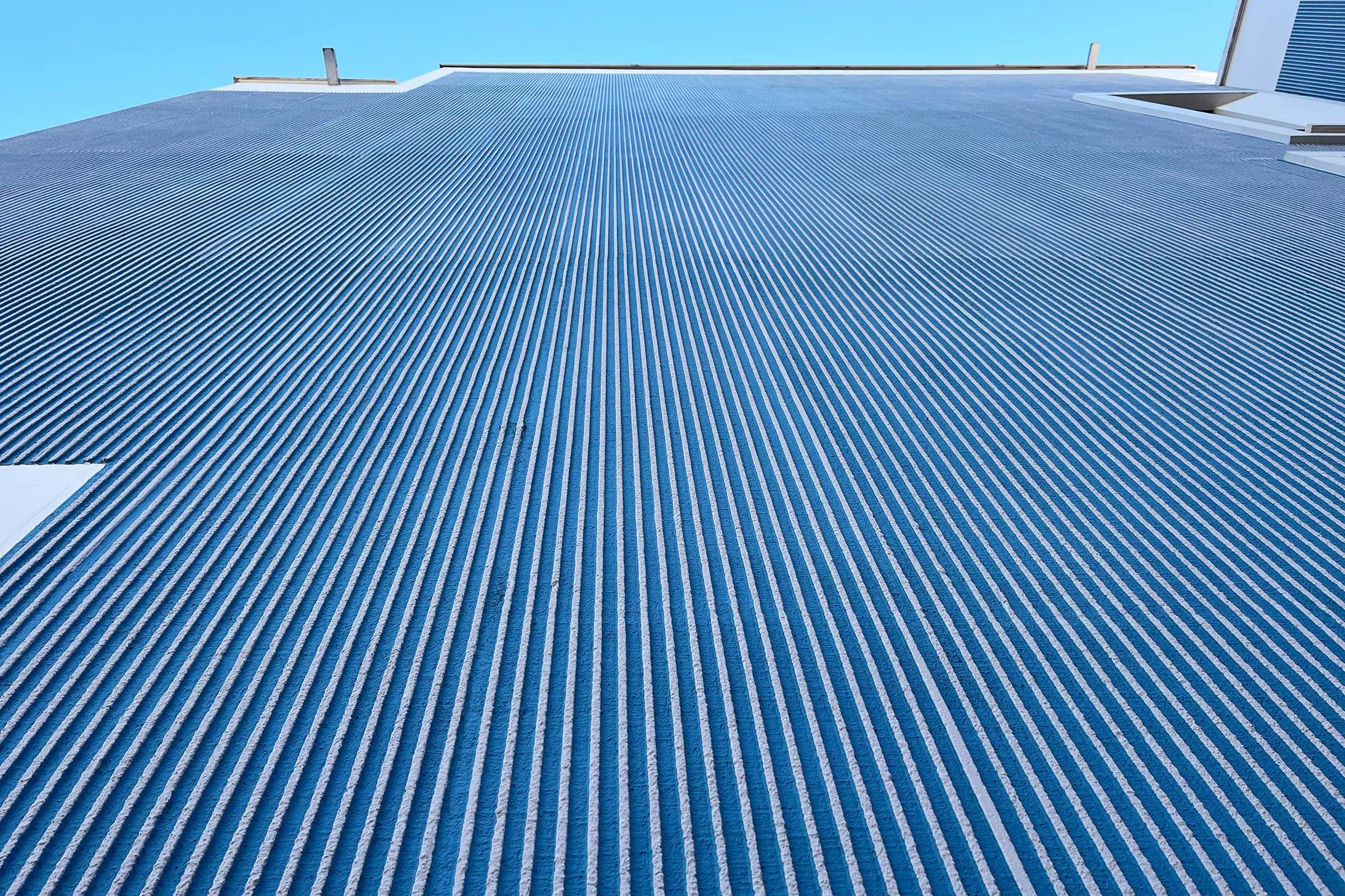 Blaue Fassade mit der Putztechnik als horizontalen Besentrich von unten