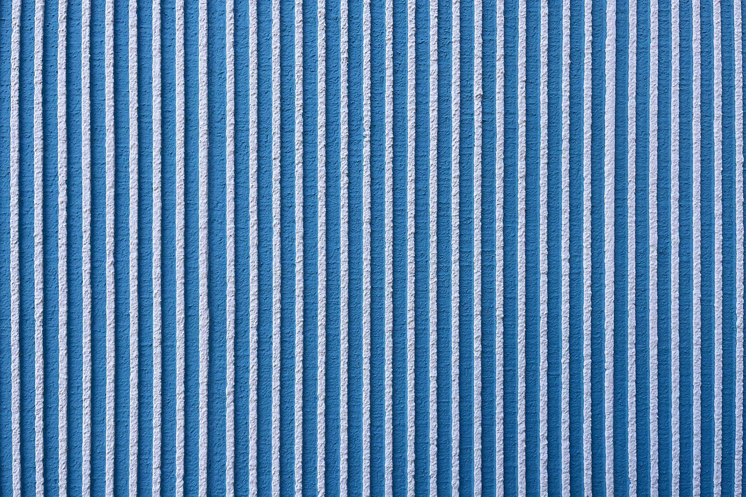 Nahaufnahme einer blauen Fassadenbeschichtung in horizontalem Besenstrich