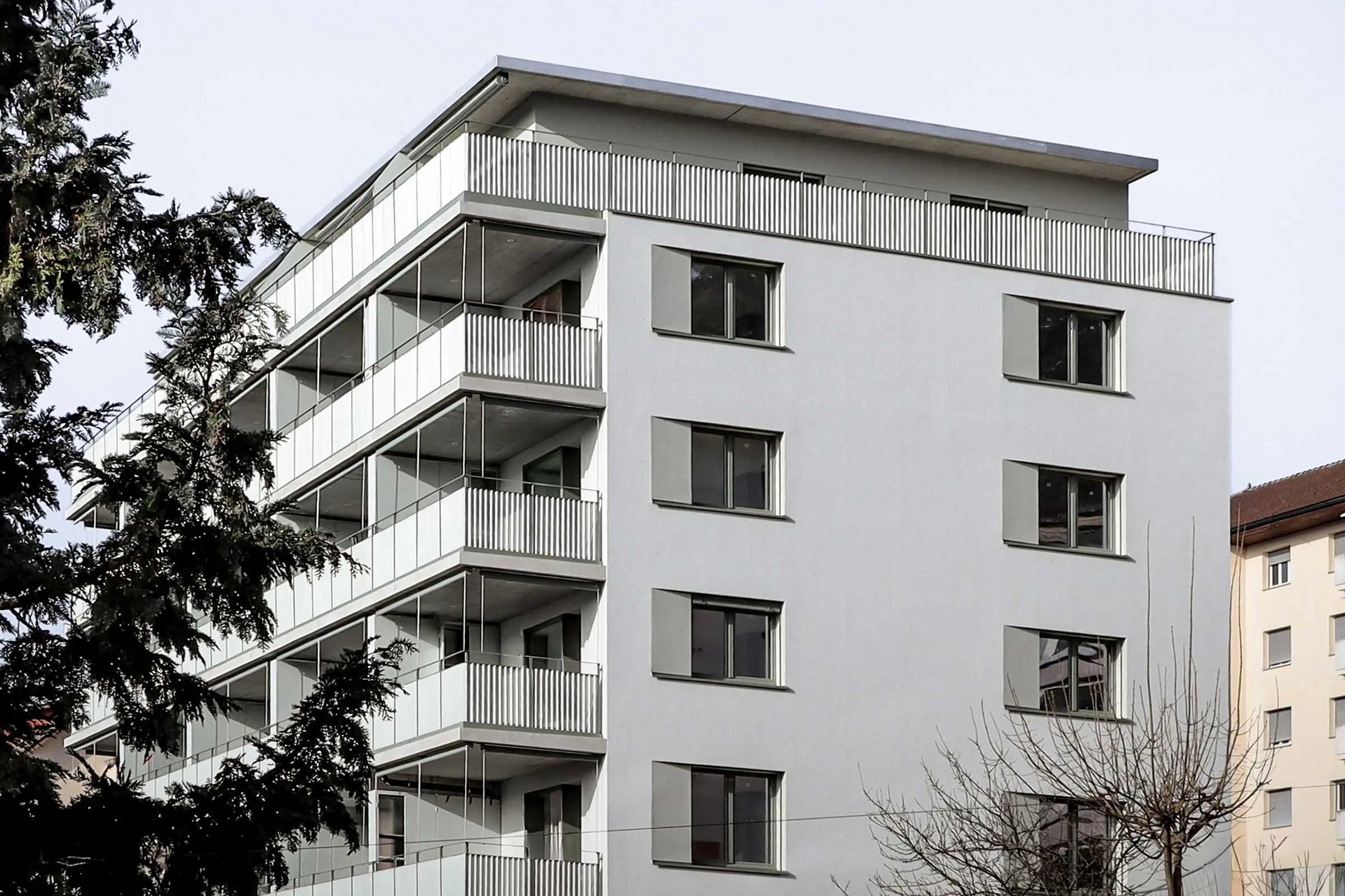 Mehrfamilienhaus mit einer ganzen Balkonreihen in heller Fassade