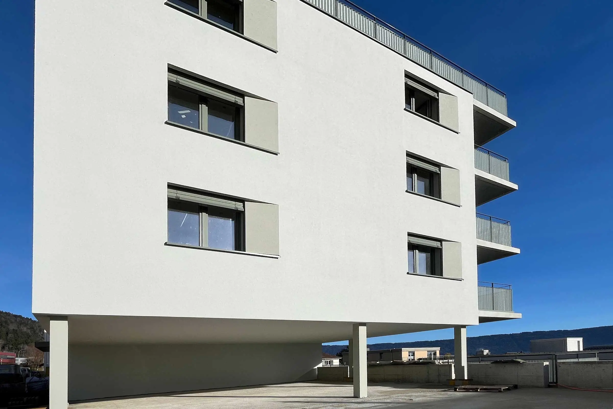 Ansicht von unten von mehrstöckigem Mehrfamilienhaus mit heller Fassadenbeschichtung