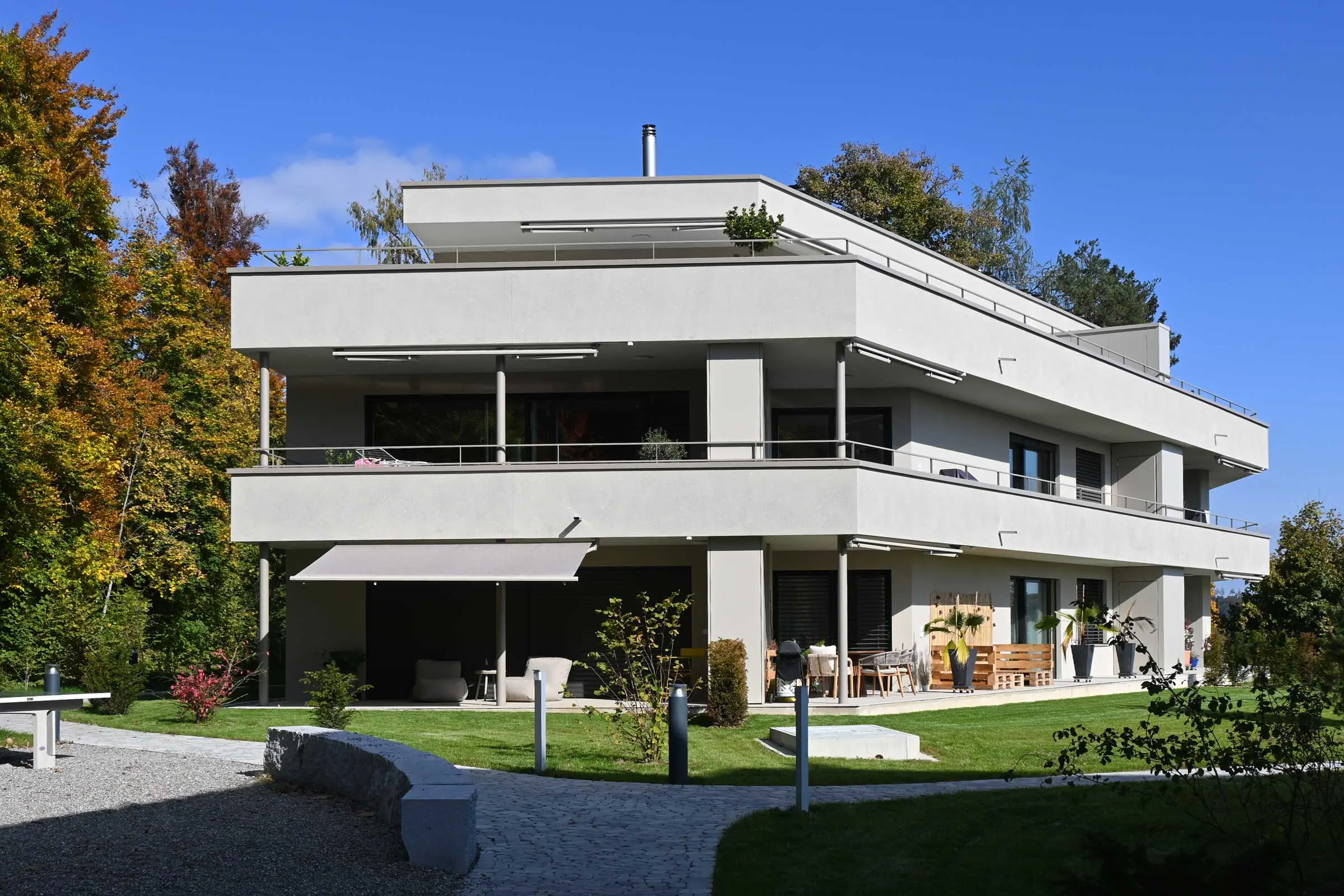 Frontansicht Mehrfamilienhaus mit 3 Stockwerken mit Balkonen und Freisitz mit hellem Fassadenputz