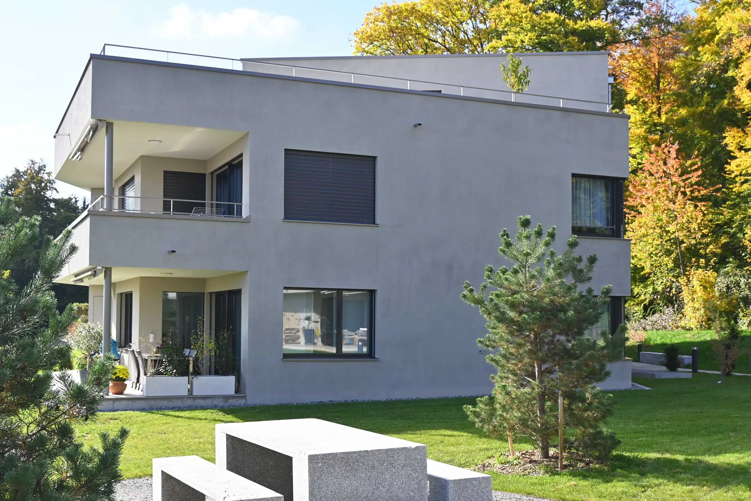 Seitenansicht von Mehrfamilienhaus mit Fenster unf Freisitz mit heller Putzfassade