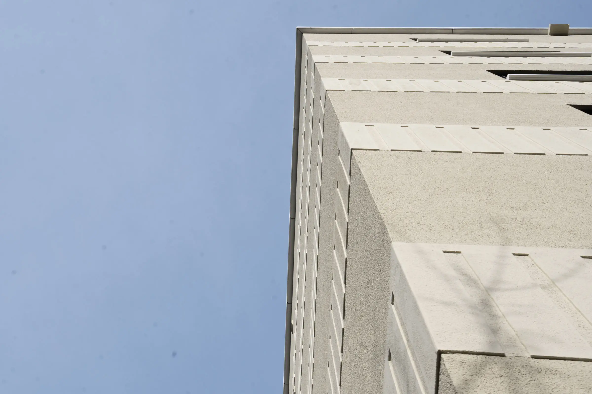 Ansicht von unten von saniertem MFH mit heller Fassadenbeschichtung StoMiral
