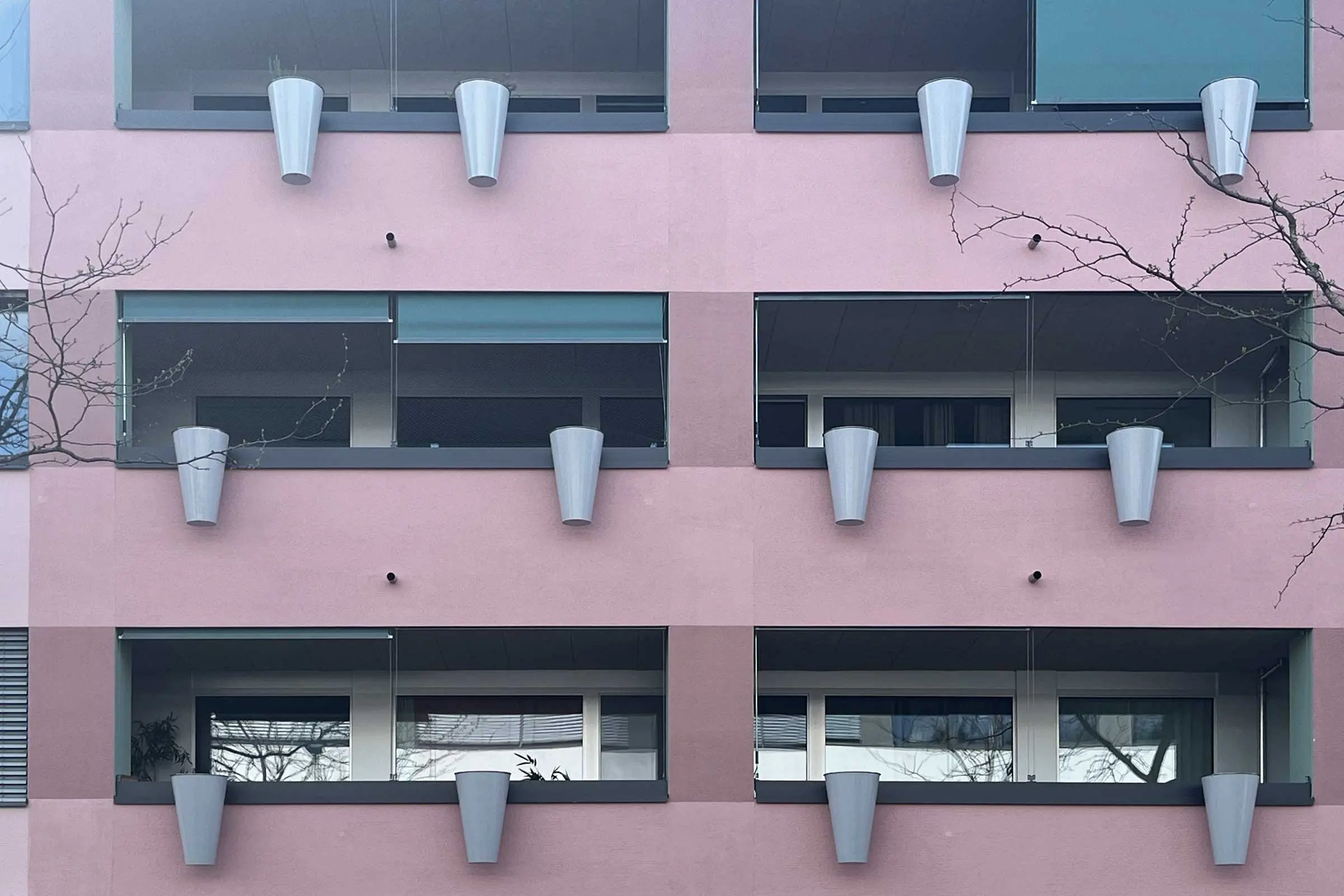 Fassade in rot-violett mit Balkonen