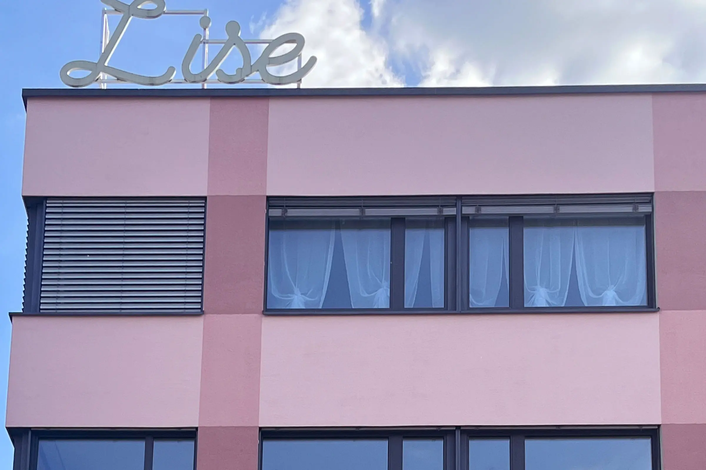 Fassade von MFH mit Fenstern mt rot-violetter Fassadenbeschichtung