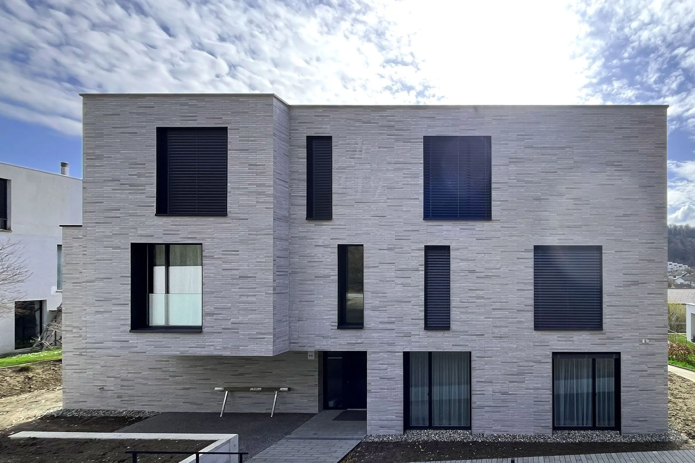 Frontalansicht Mehrfamilienhaus mit grau-beiger Klinkerfassade