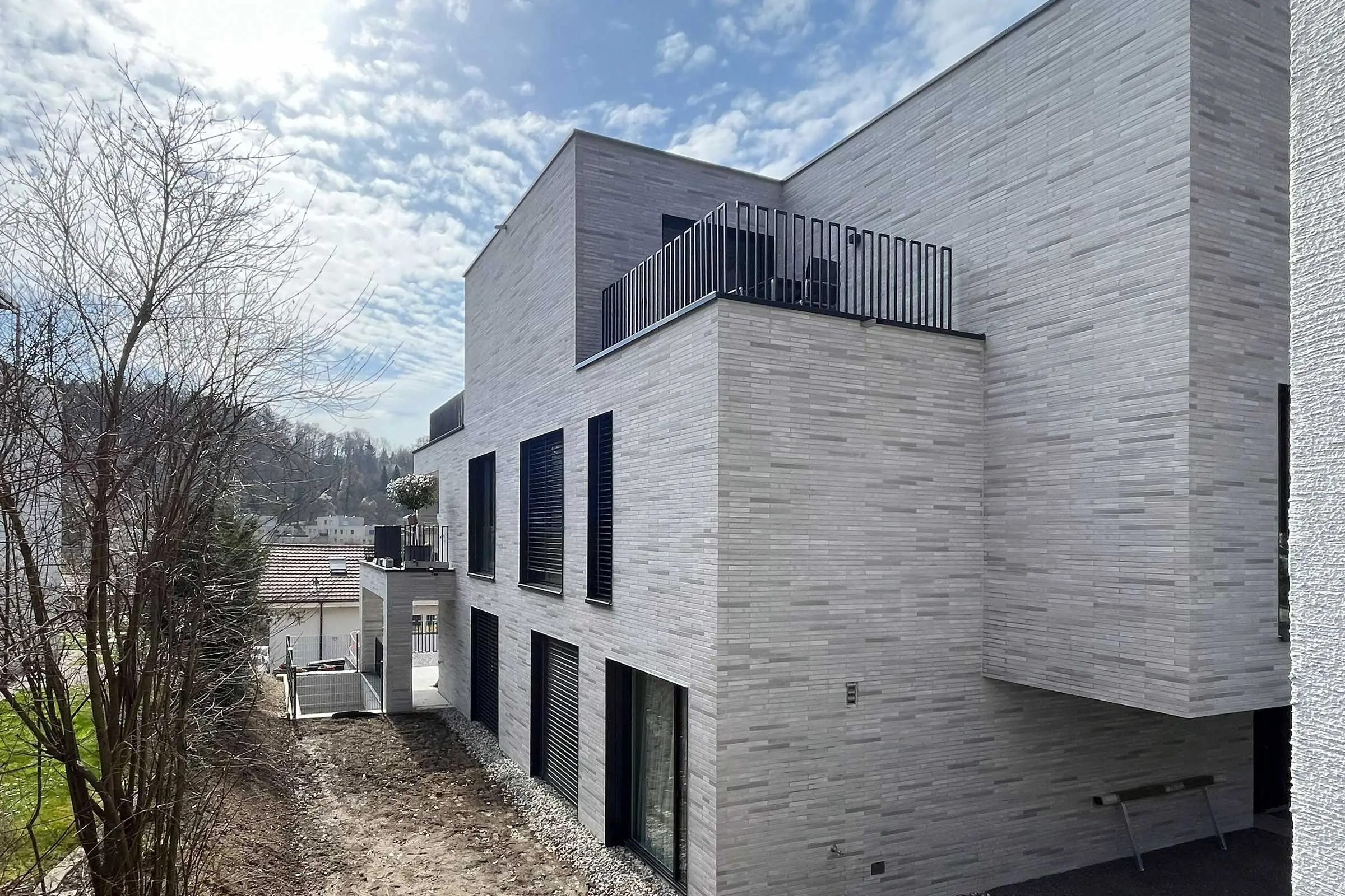 Seitenansicht Mehrfamilienhaus mit grau-beiger Klinkerfassade
