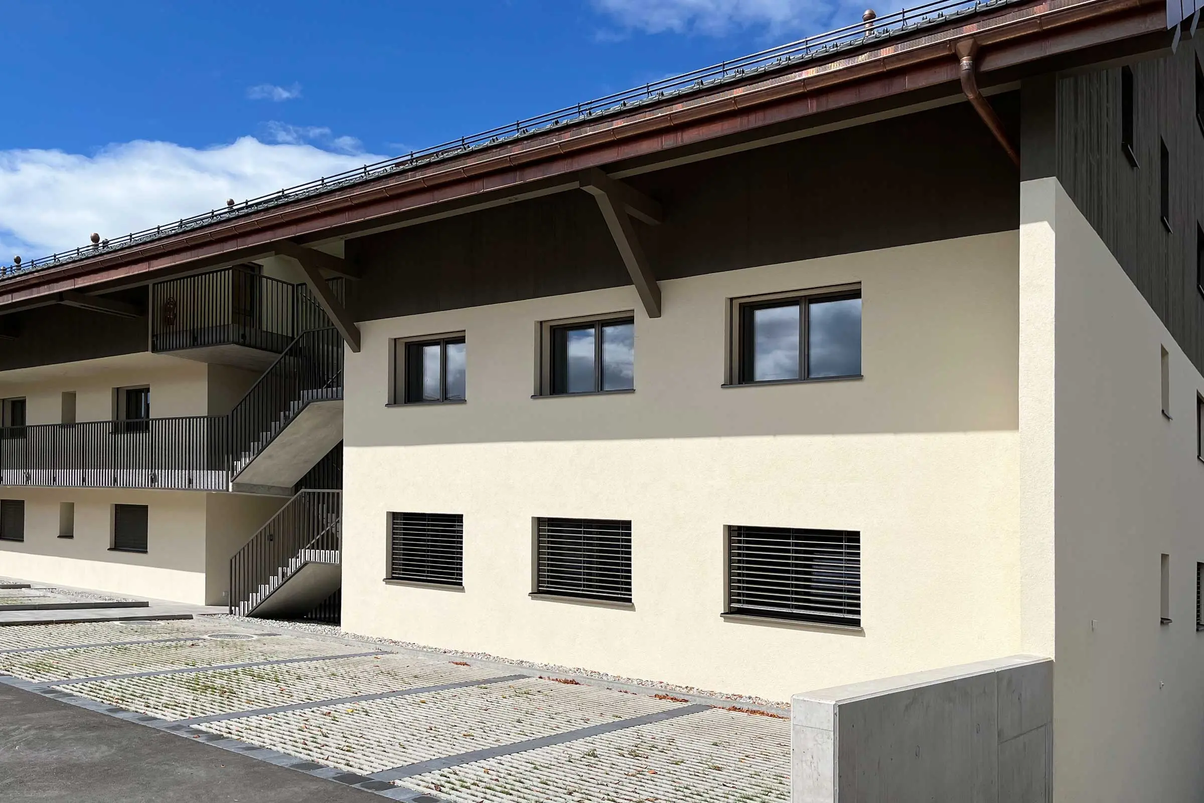 Immeuble collectif avec vue de la baie vitrée et des escaliers avec une façade claire