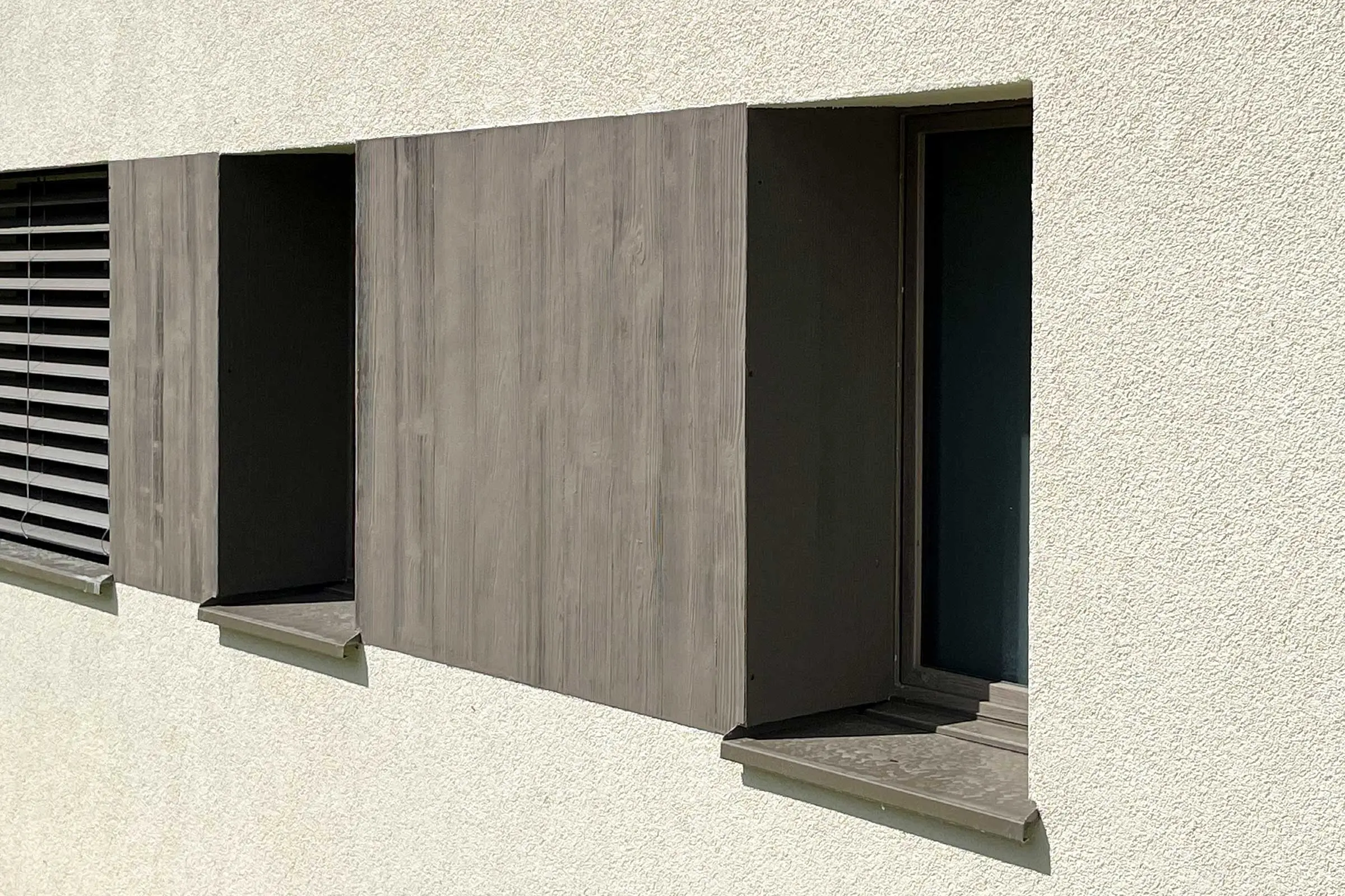 Vue de la rangée de fenêtres avec revêtement en bois gris