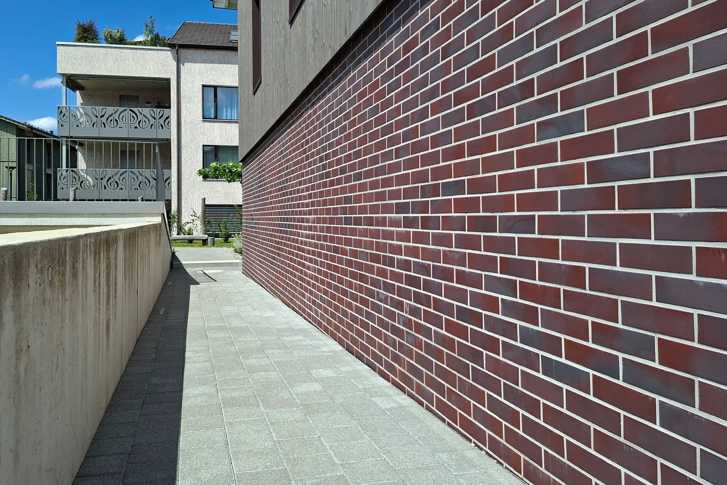 Nahaufnahme Sockel von Mehrfamilienhaus mit rotem Klinker