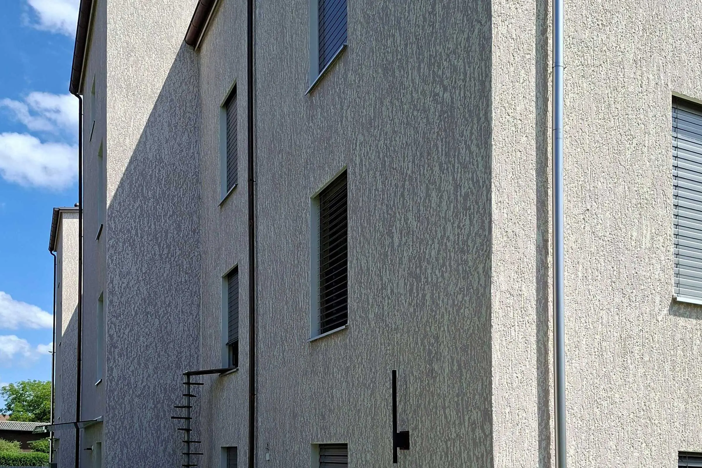 Fassade von Mehrfamilienhaus mit moderner beiger Putzfassade in StoSignature Putztechnik in beige