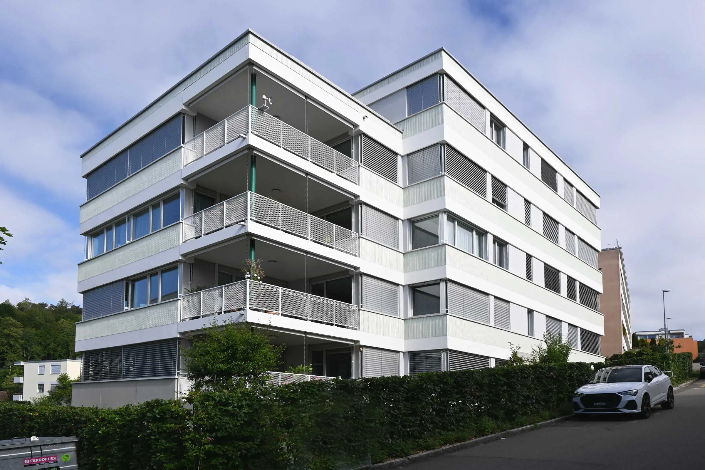Eckansicht mit Balkonen von Mehrfamilienhaus mit heller Fassade