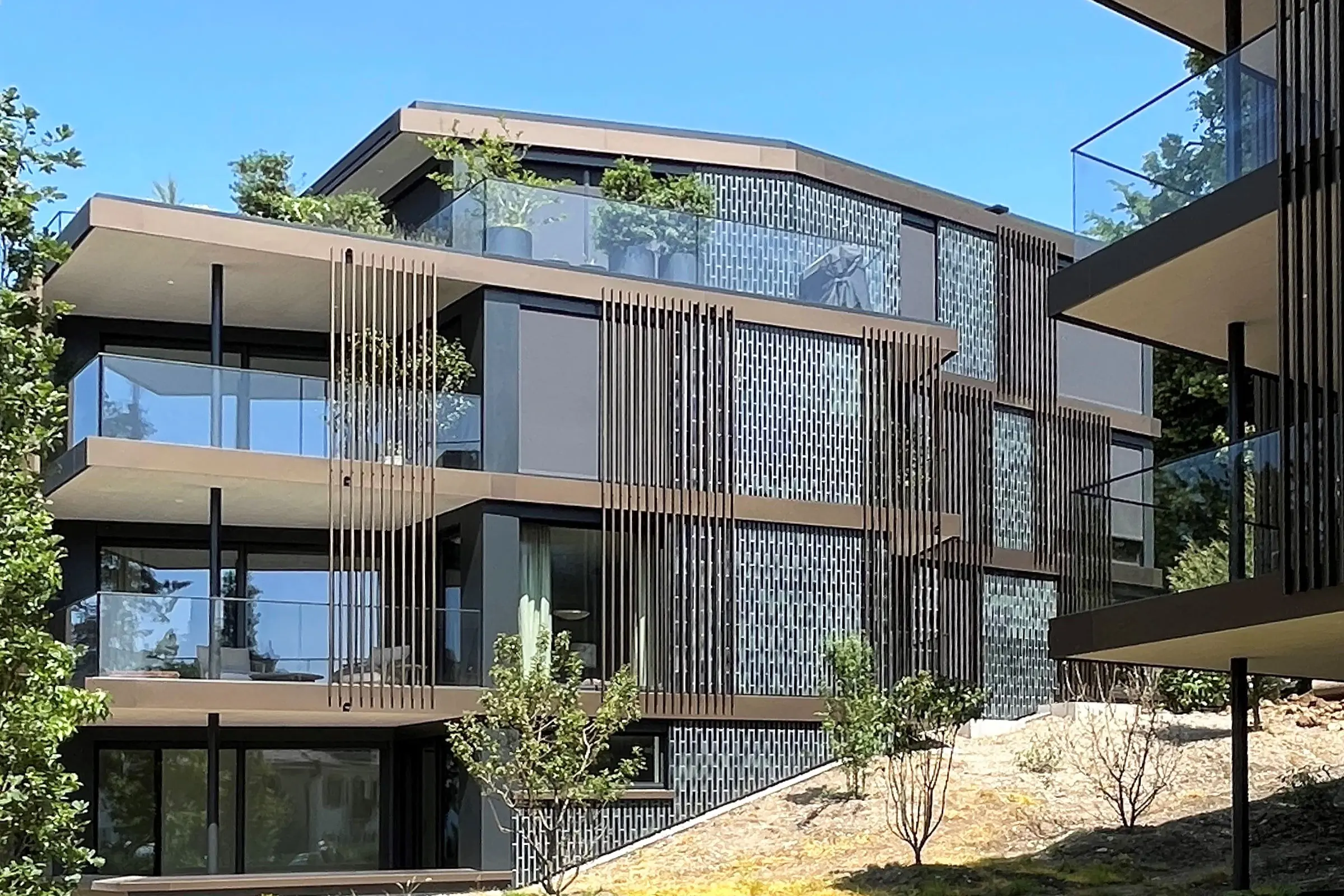 Immeuble collectif avec de grandes façades vitrées et une façade en plaques de céramique grise