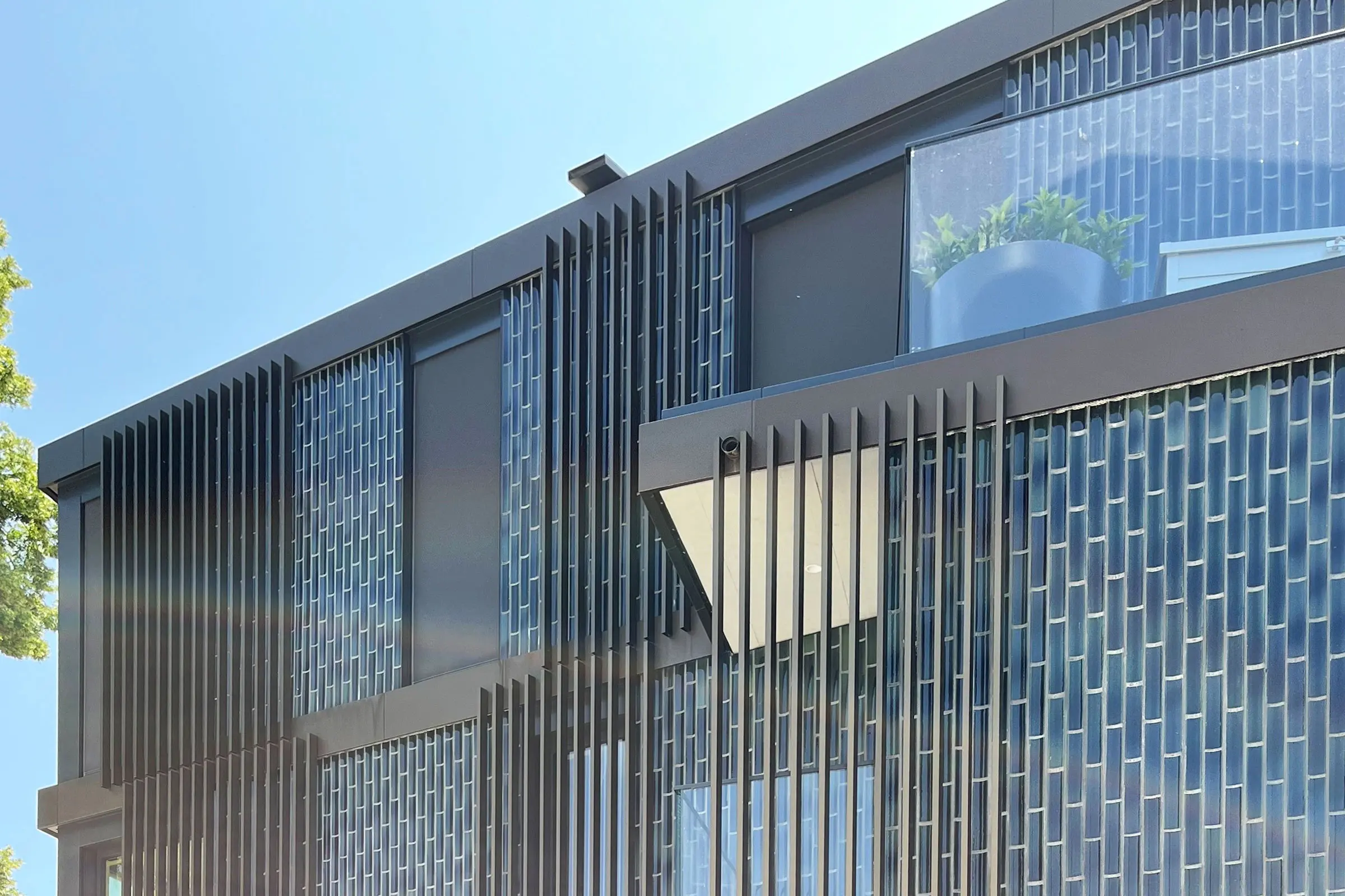 Vue de dessous de la façade d'un immeuble d'habitation avec une façade en céramique grise et de gran