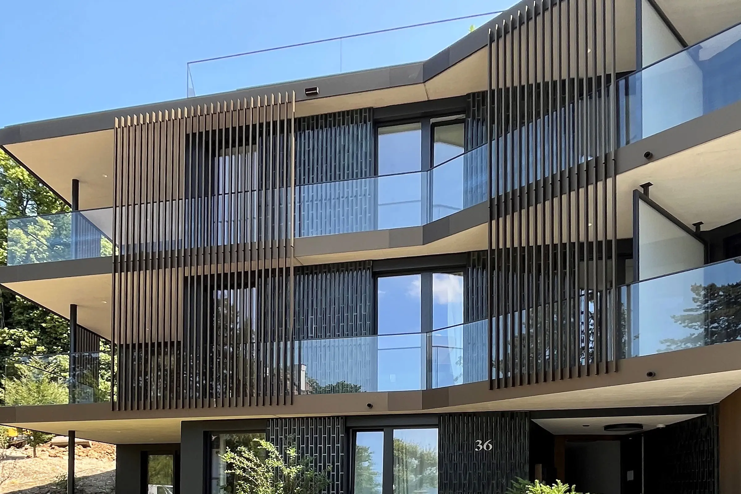 Immeuble collectif avec grandes baies vitrées et façade en céramique grise