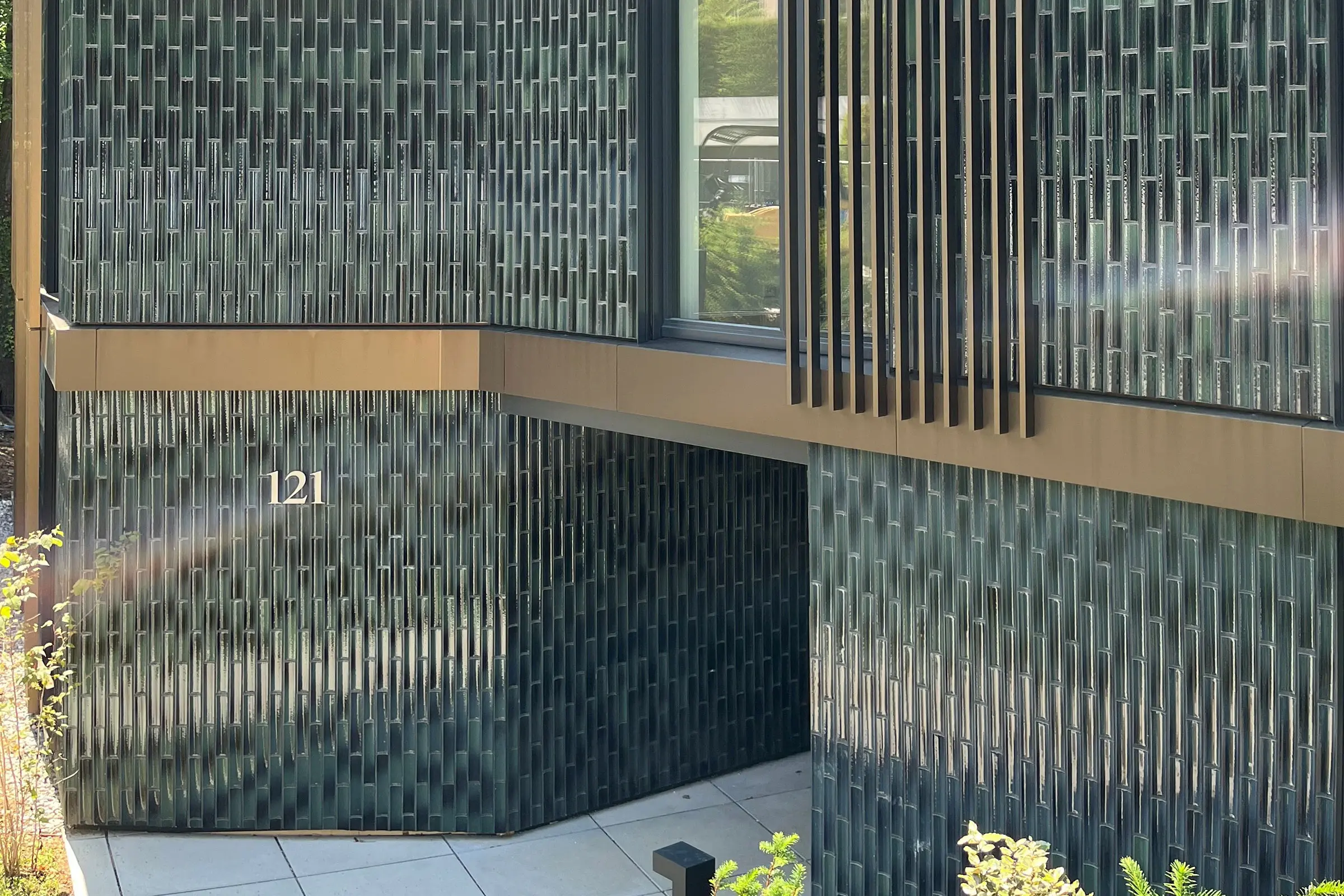 Gros plan sur l'entrée avec façade en céramique grise