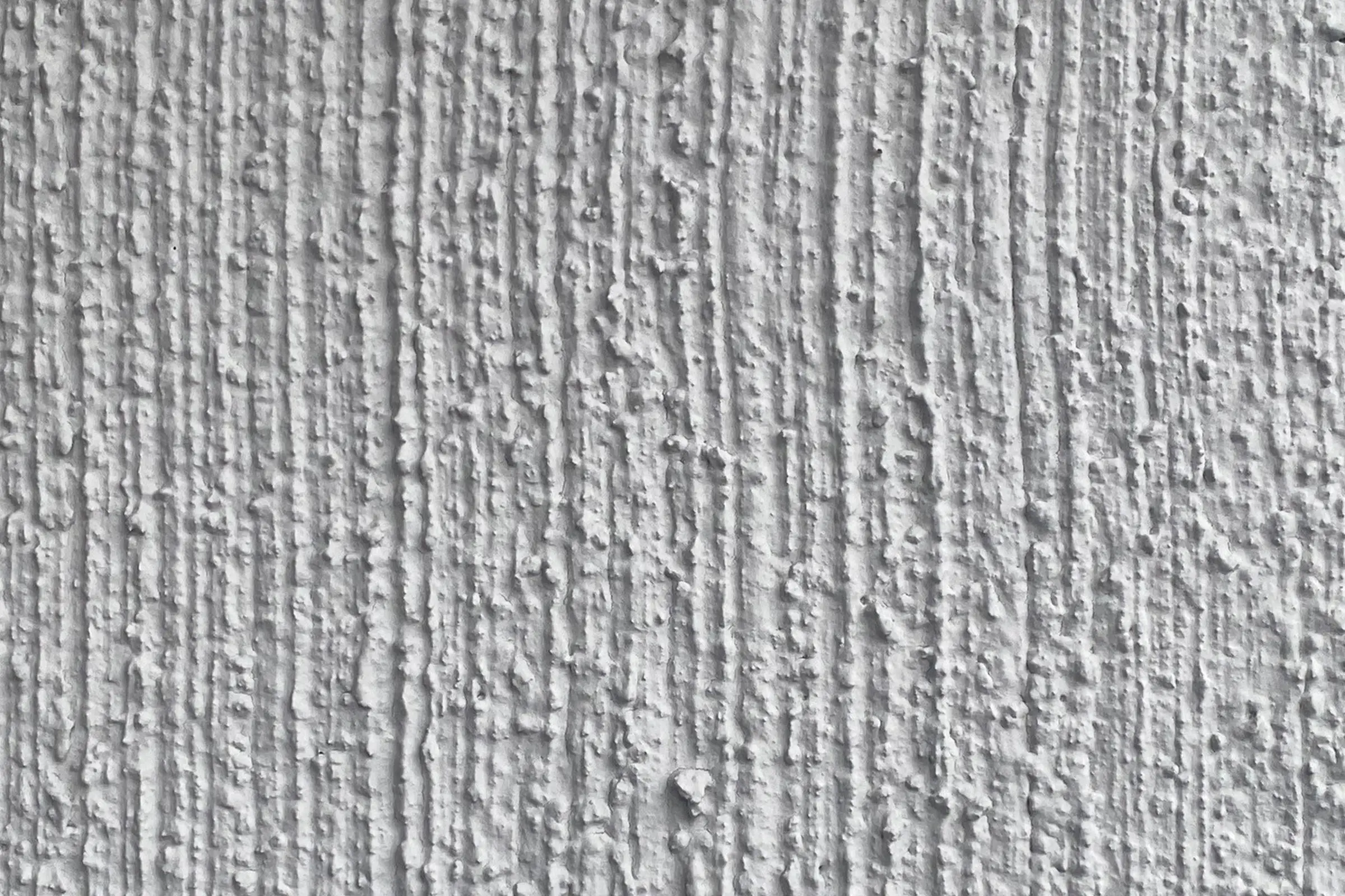 Nahaufnahme von hellgrauem Putz an einem Mehrfamilienhaus