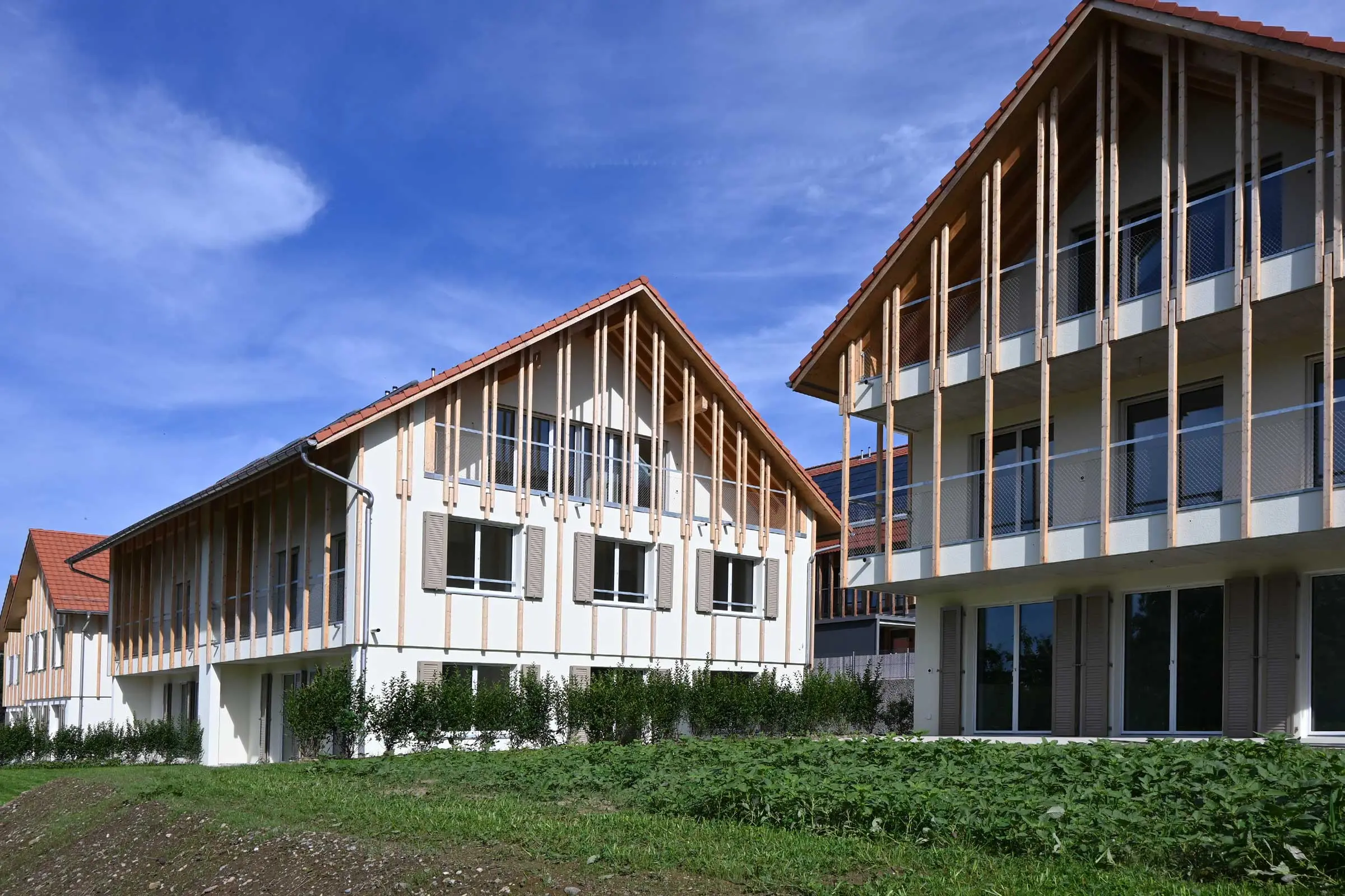 Wohnüberbauung mit Holzlatten auf hellem Putz