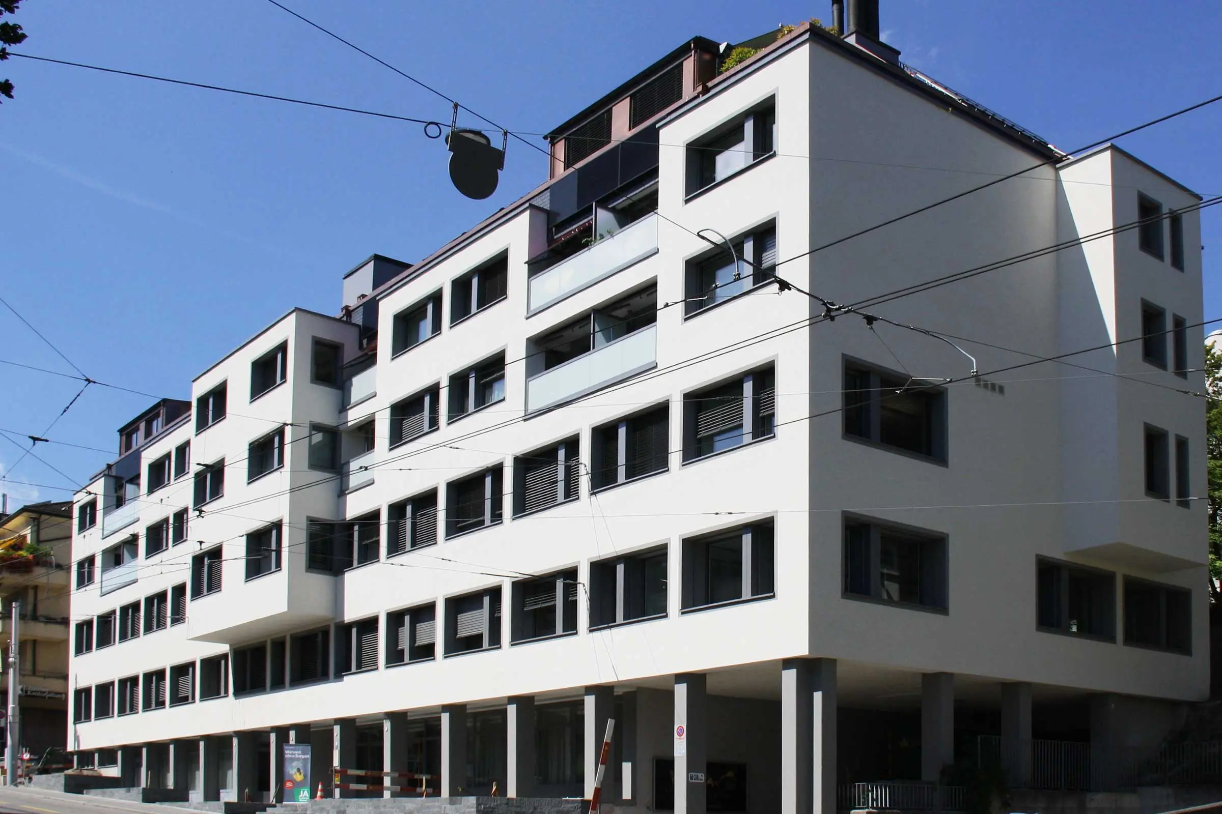 Immeuble d'habitation avec une façade claire et des encadrements gris autour des fenêtres